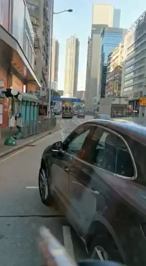 片段開始可見，一輛私家車停泊在小巴前方。