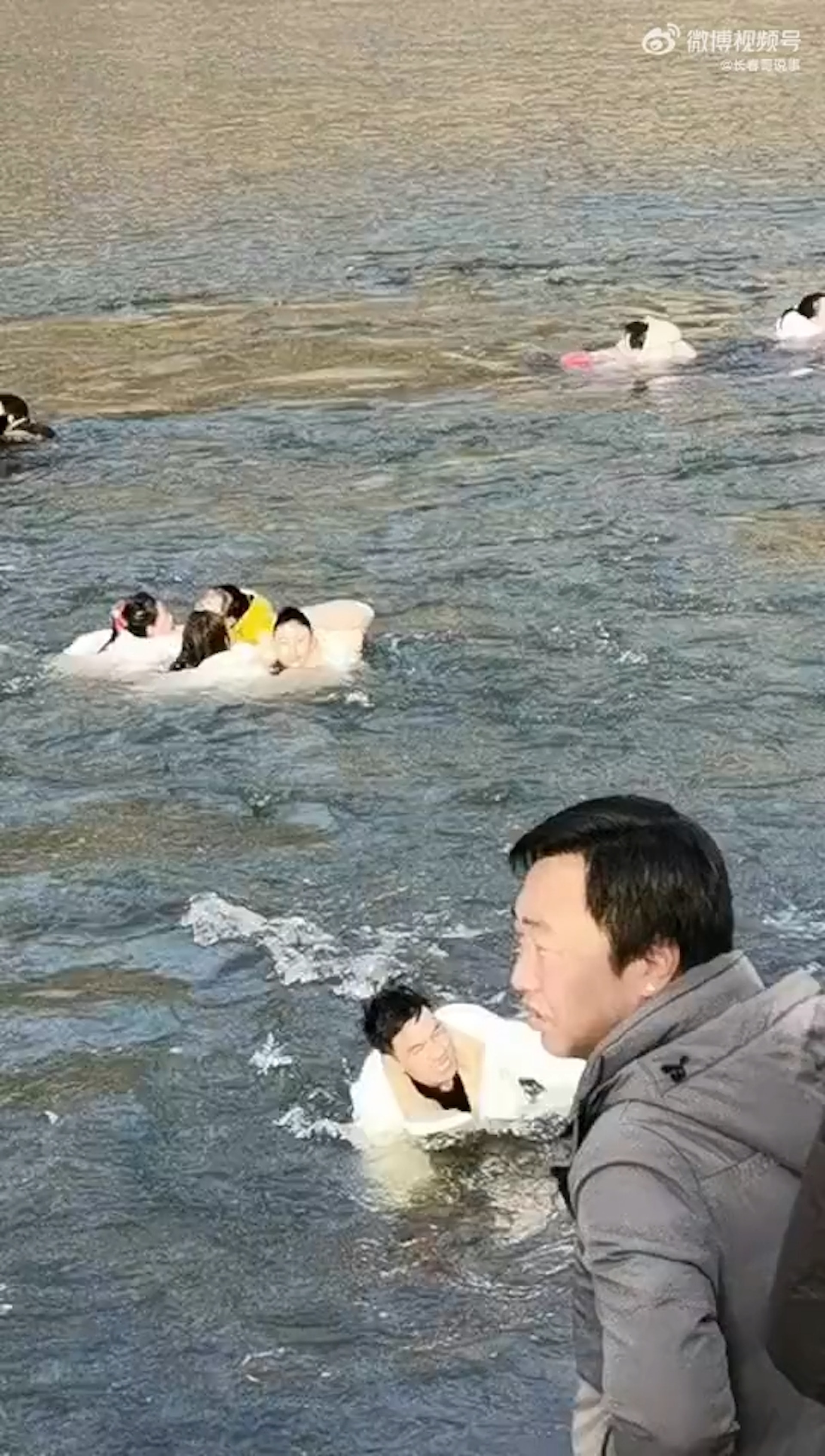 河水突然上漲,多人被河水沖走,在洶湧的水流中求生。(影片截圖) 河水突然上漲,多人被河水沖走,在洶湧的水流中求生。(影片截圖)