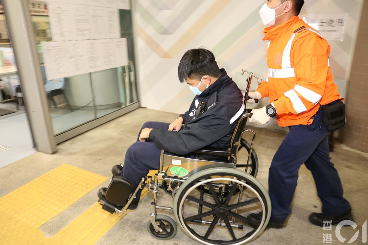 一名警员坐轮椅送往律敦治医院治理。（黄江奇摄）