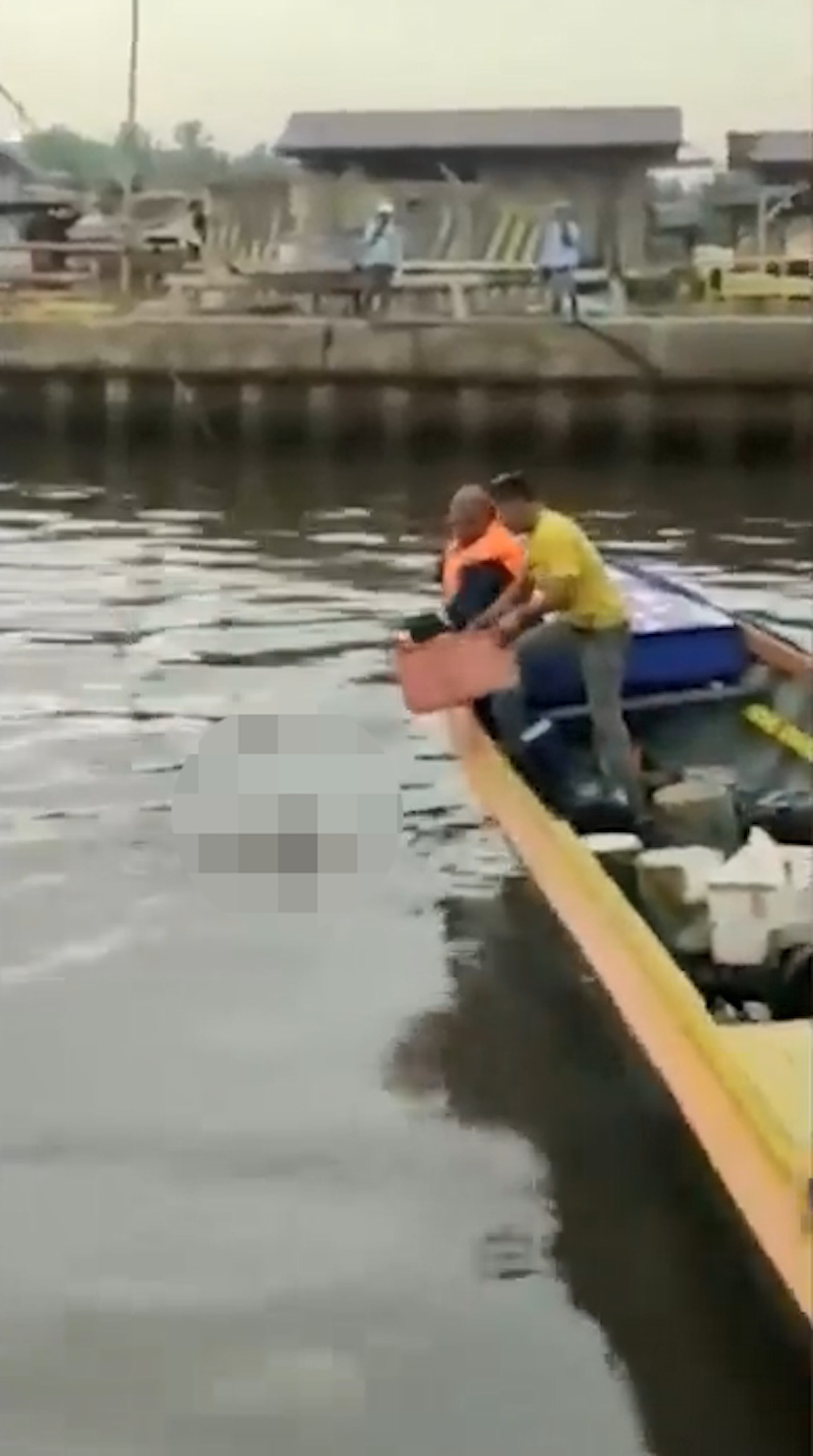 鱷魚游近岸邊小艇鬆口，艇上2名男子將男童遺體撈起。（fb影片截圖）