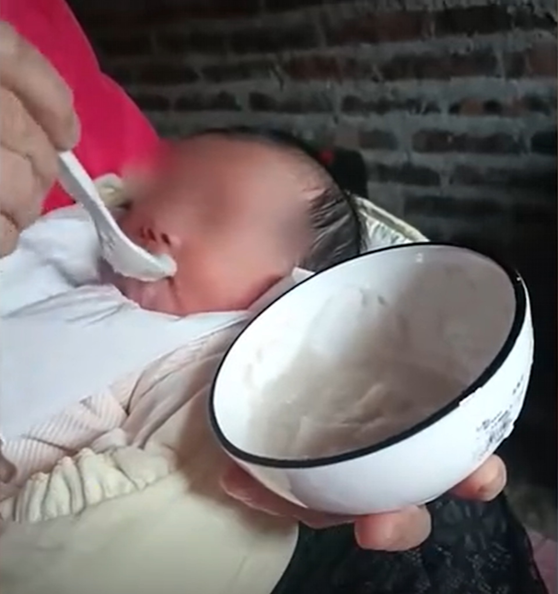 奶奶用匙餵嬰兒吃米糊。（相片截圖自秒聞視頻）