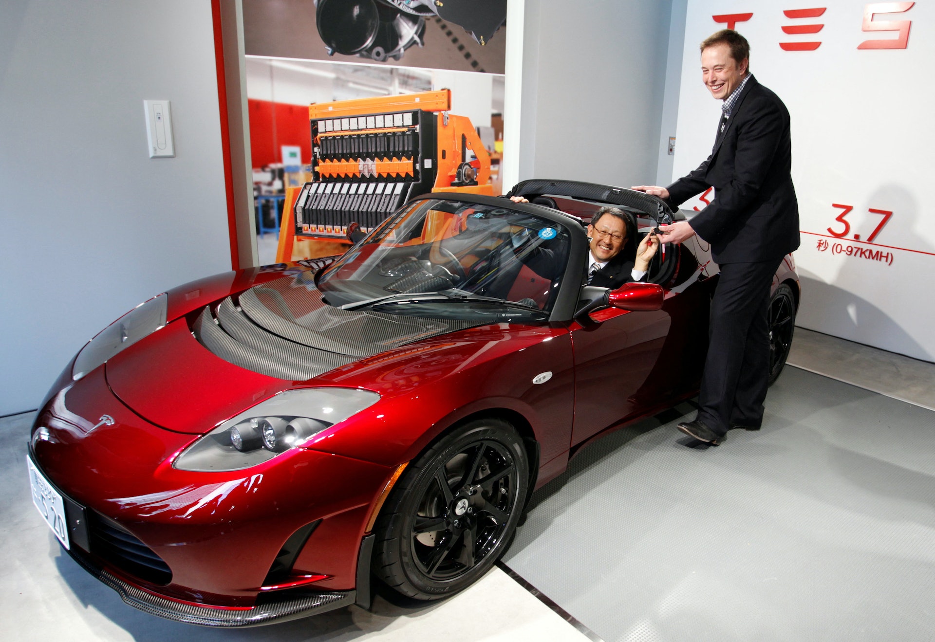 錯過Tesla：豐田章男在2012年曾以5000萬美元買下特斯拉2.4%的股份，並押注電動車發展，可惜因電池質量不穩定而放棄。圖為2010年11 月，馬斯克向豐田章男贈送了特斯拉Roadster電動汽車的鑰匙。（Reuters）