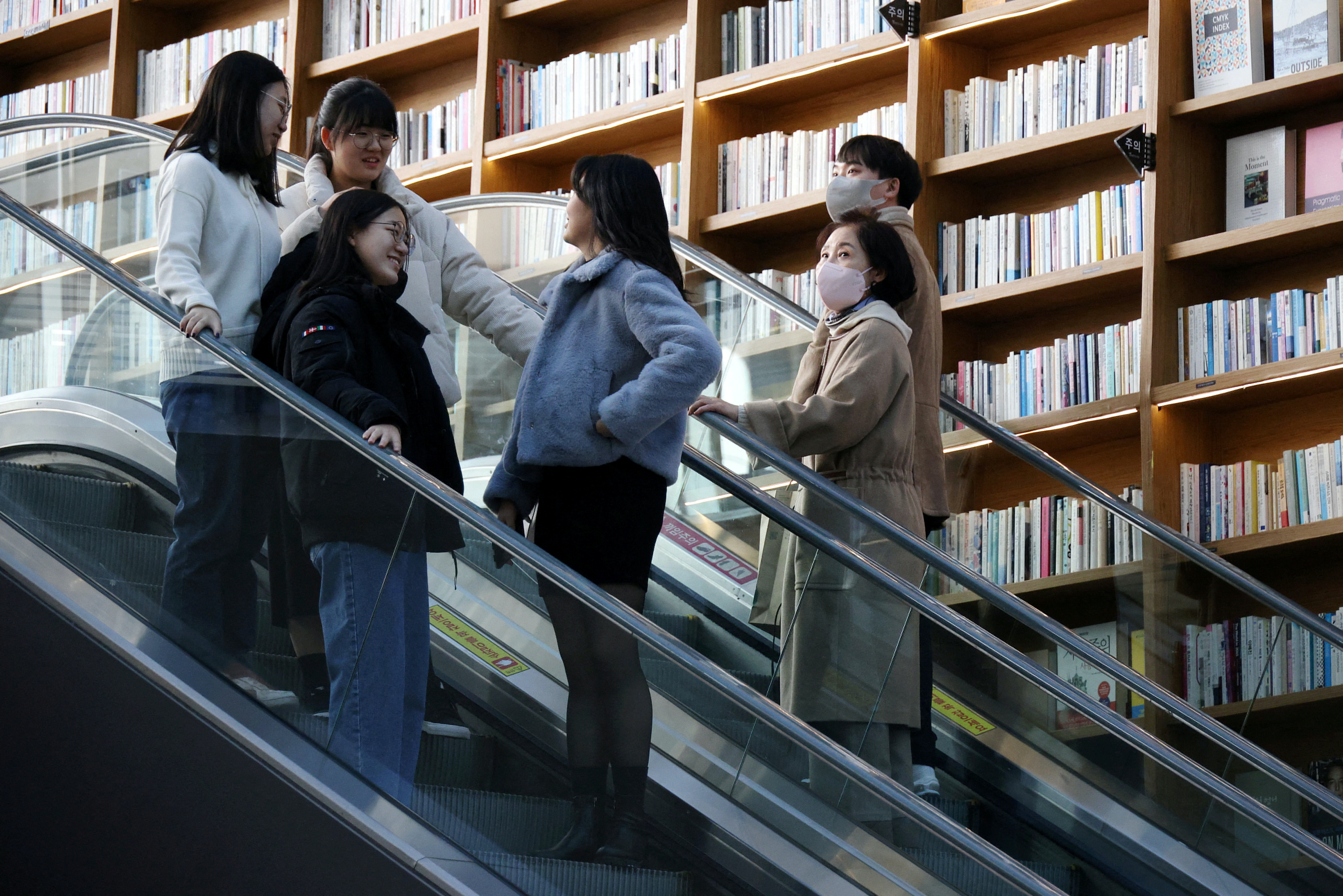 圖為1月30日，首爾一間書店，可見有人帶着口罩，有人除下了口罩。（Reuters）
