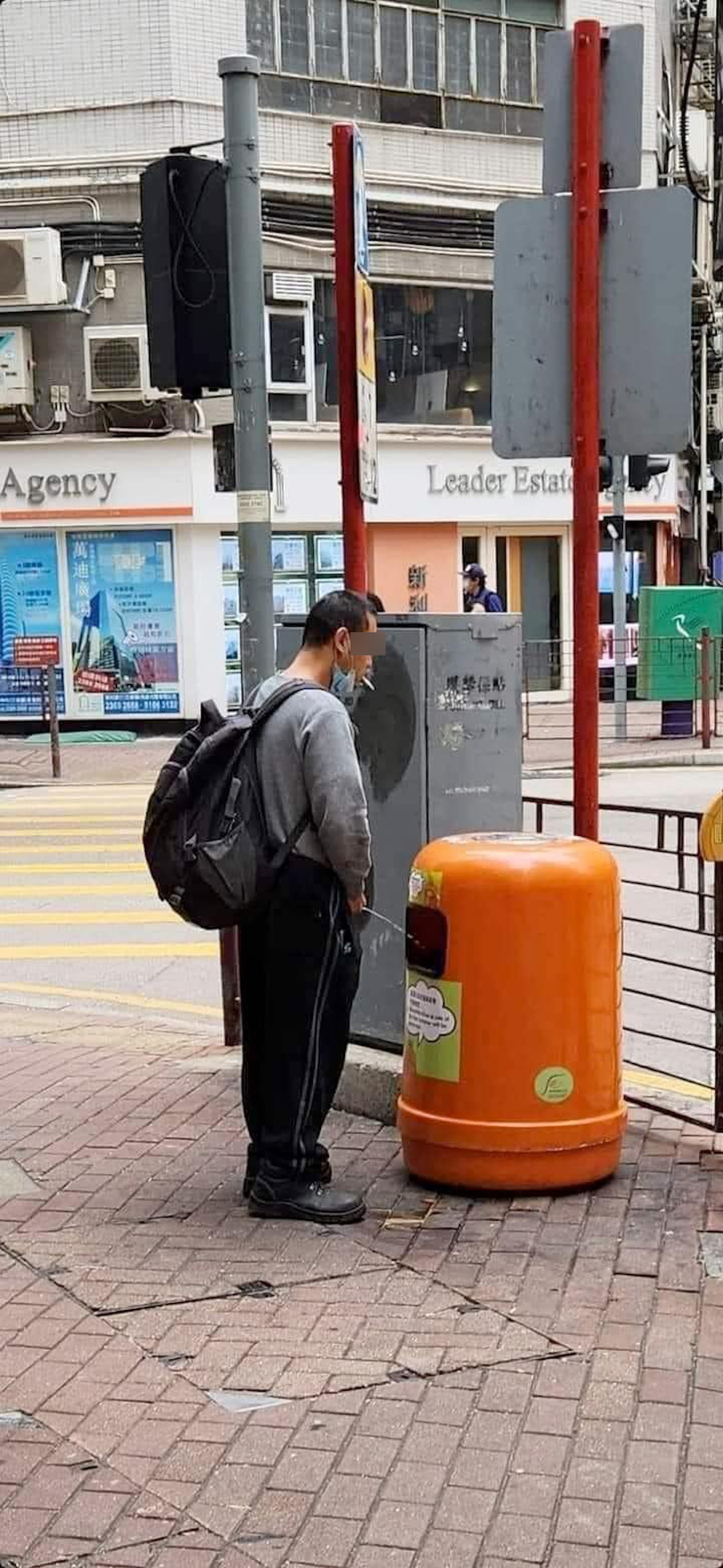 網上瘋傳相片，顯示1名男子竟將街頭的垃圾堆當成尿兜，當眾對着垃圾桶小便，嘴上還拉下口罩叼着煙頭。（facebook圖片）
