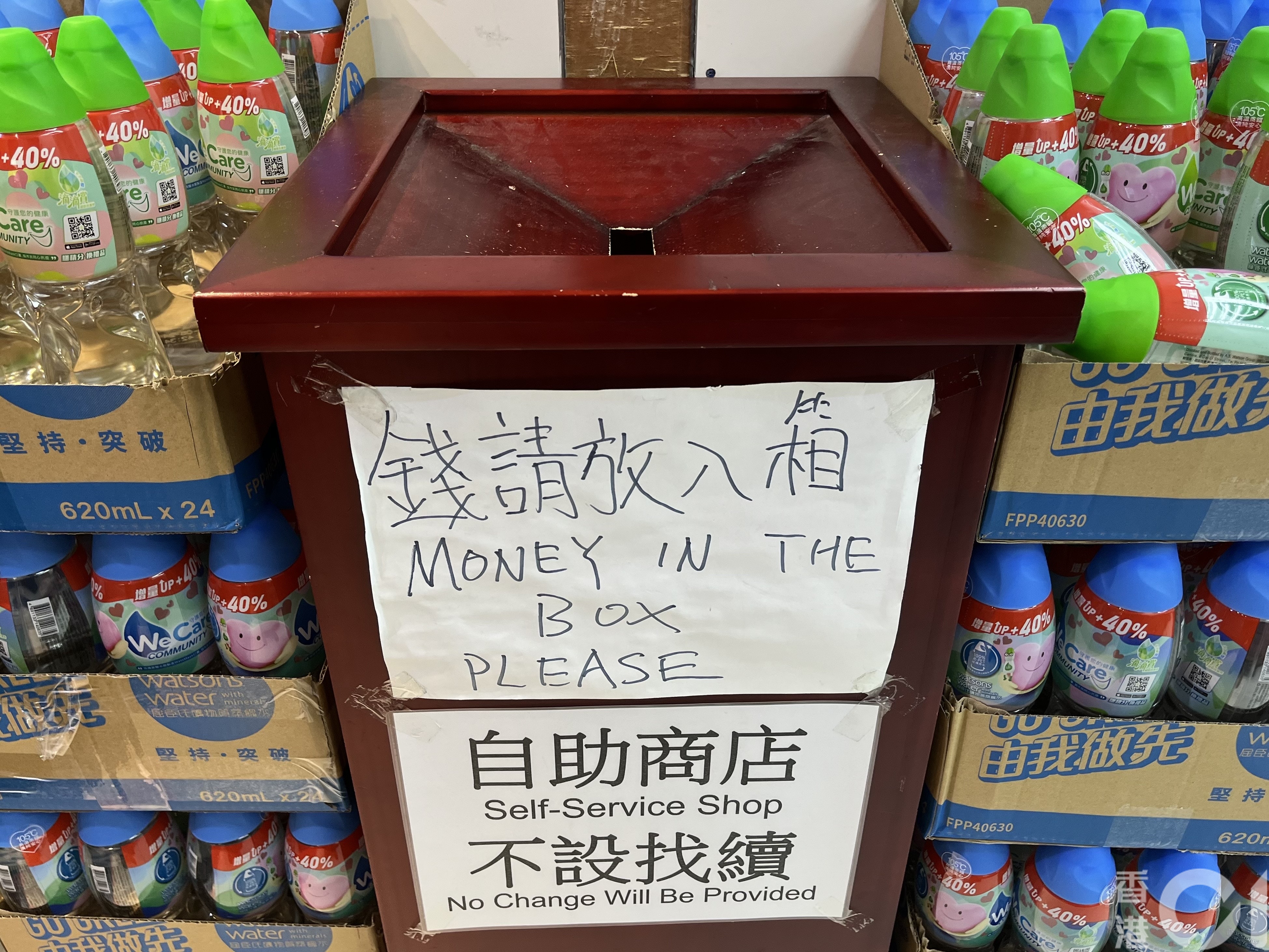 「北角士多」城市花园商场分店3月18日可见,所有饮品放置在纸箱内,门旁则放有钱箱,并贴上不设找赎的告示。(欧阳德浩摄)