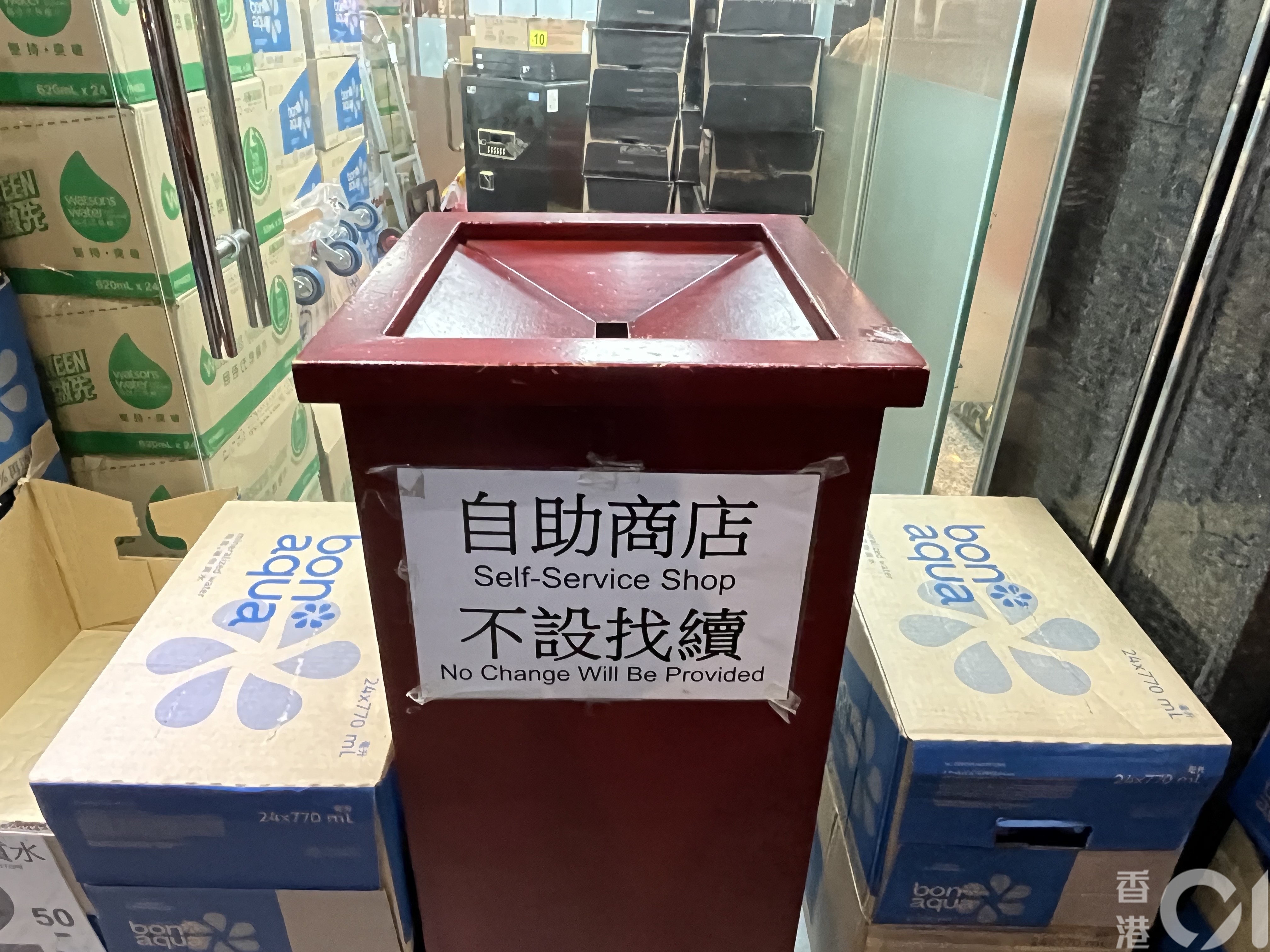 「北角士多」城市中心分店在3月18日可见,所有饮品放置在纸箱内,门旁则放有钱箱,并贴上不设找赎的告示。(欧阳德浩摄)
