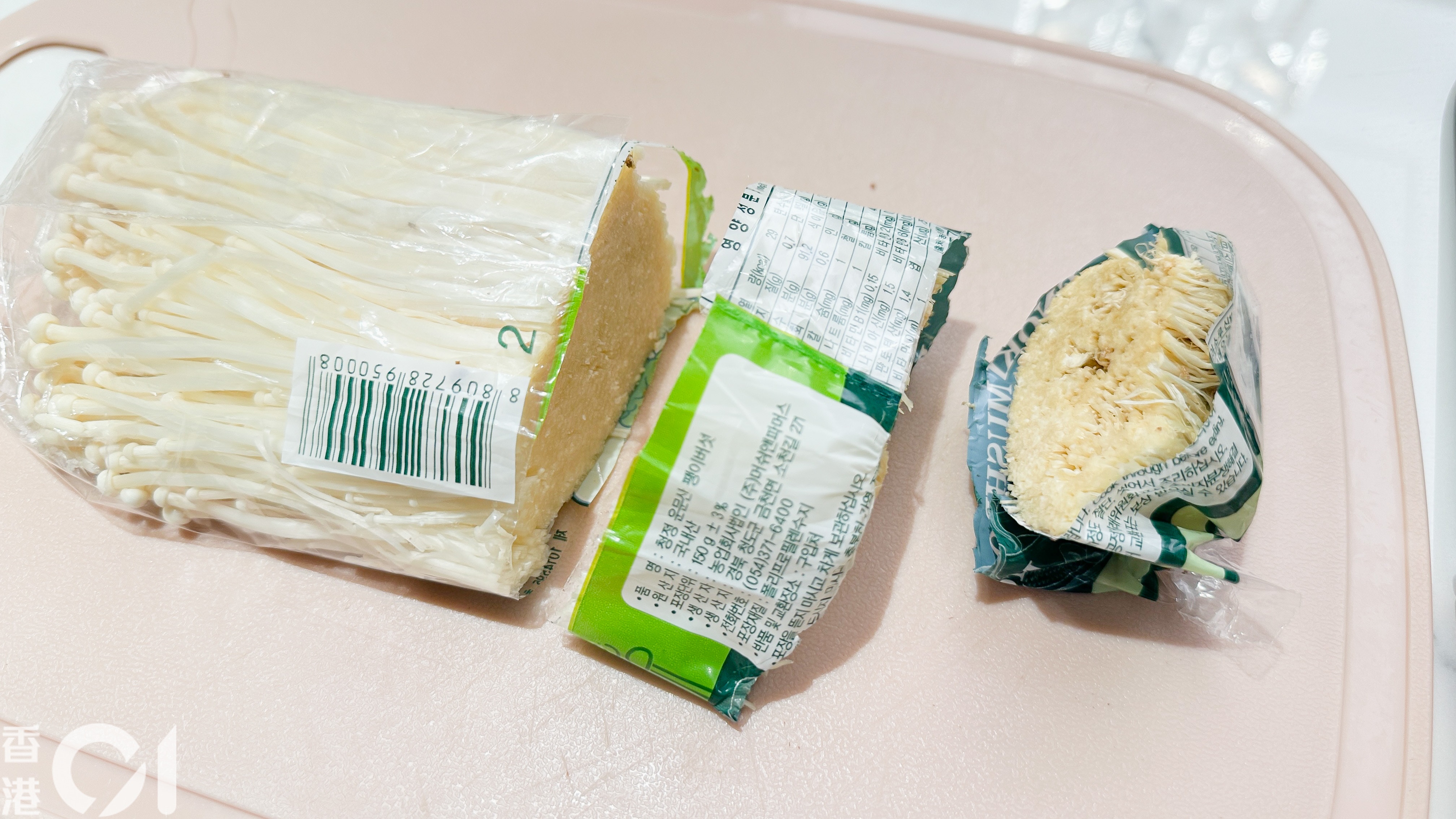 切金菇後不想菇絲四散，連包裝袋一起切，管住金菇體。（尹嘉蔚攝）