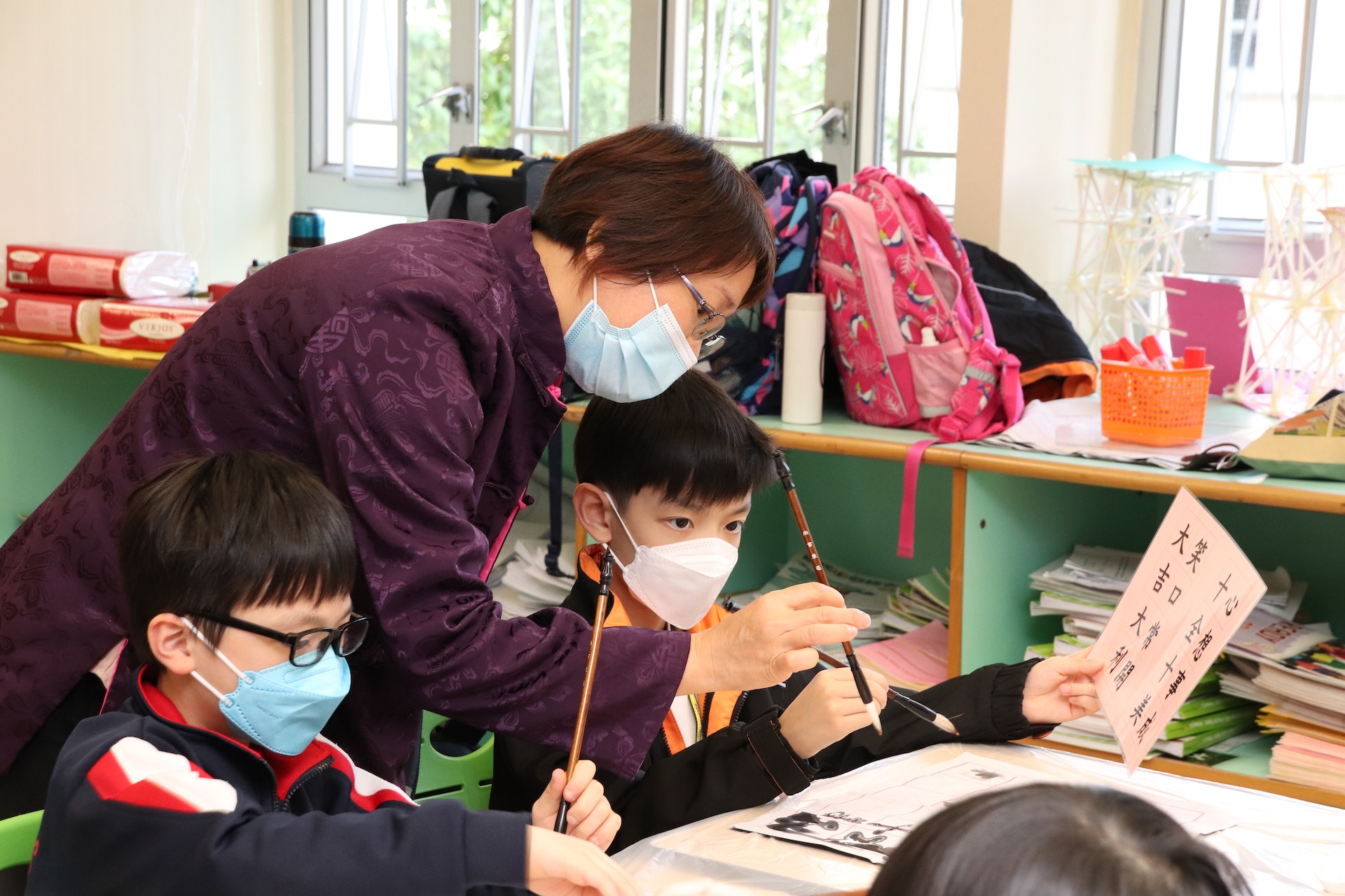 在「中國」,擔任務服員的學生身穿漢服,與教師一同帶領到訪的學生習字、製作風車、繪製扎染圖案。(聖公會聖提摩太小學提供) 在「中國」,擔任務服員的學生身穿漢服,與教師一同帶領到訪的學生習字、製作風車、繪製扎染圖案。(聖公會聖提摩太小學提供)