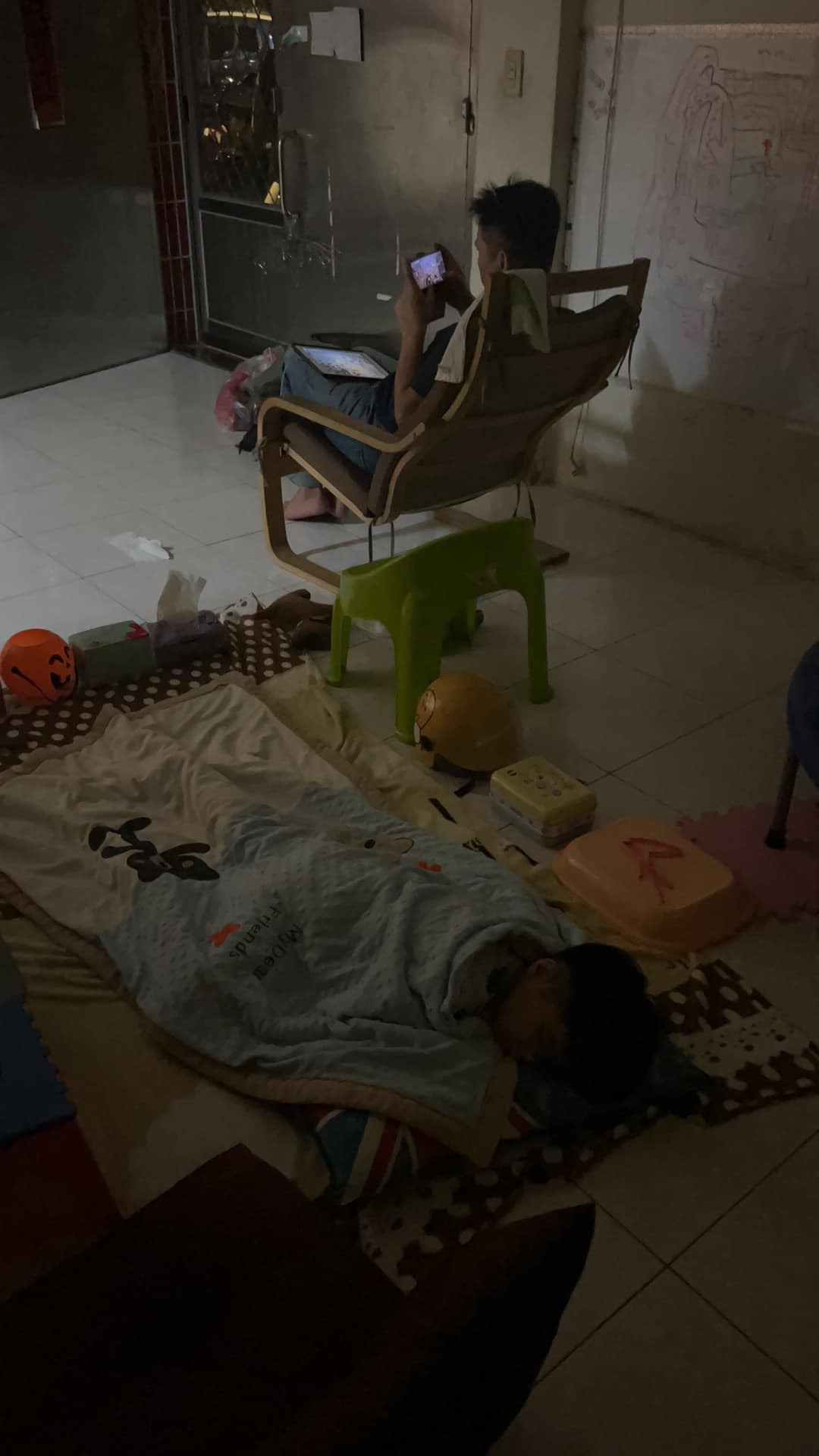 台灣人妻指丈夫周未才回家，所以孩子特別喜歡跟着他，但他回家卻只顧着玩電話，連孩子睡在地上也不為所動，感到不滿故拍照公審到網上。（FB圖片）