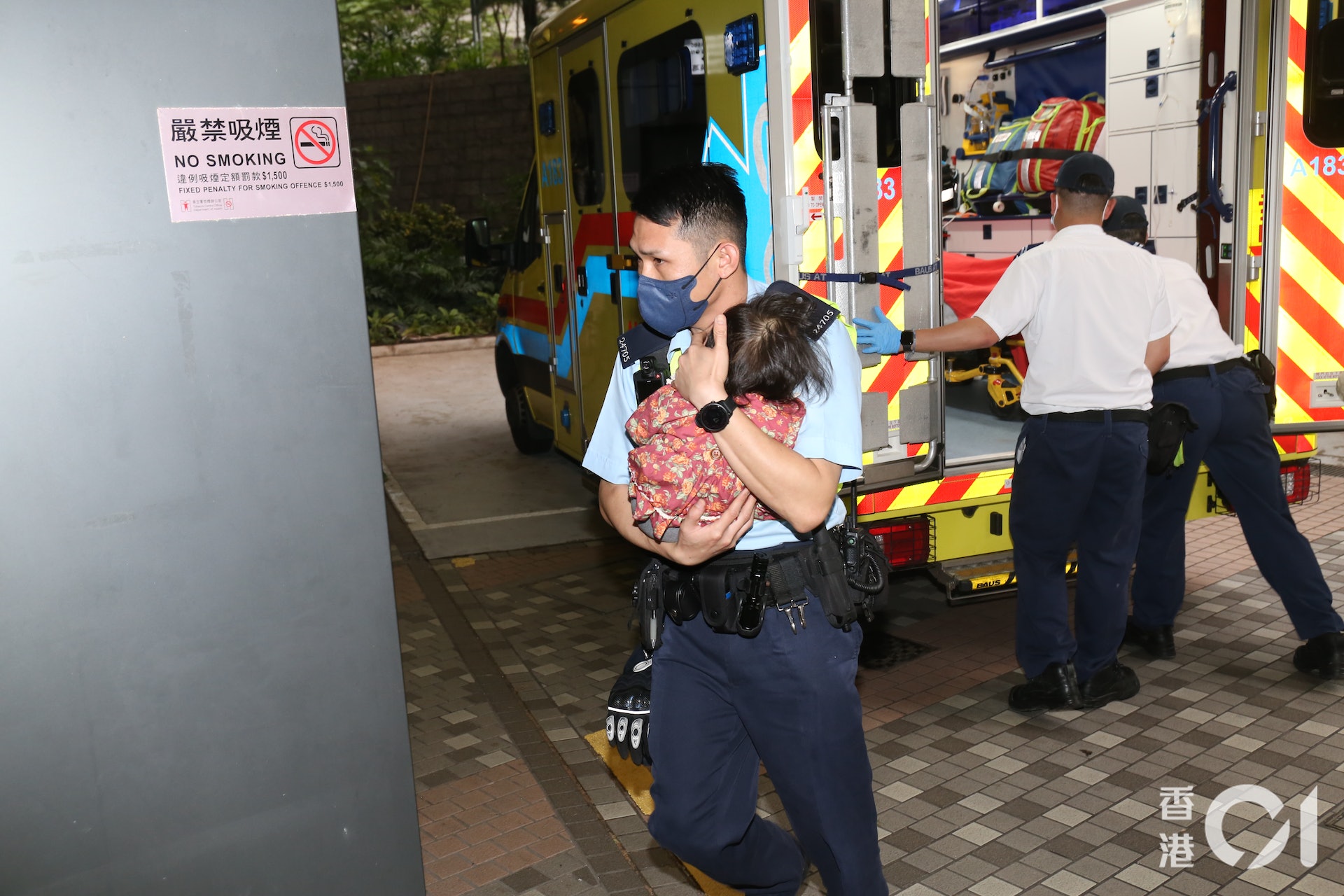 一女童由警員抱著陪同送院。(陳浩然攝) 一女童由警員抱著陪同送院。(陳浩然攝)