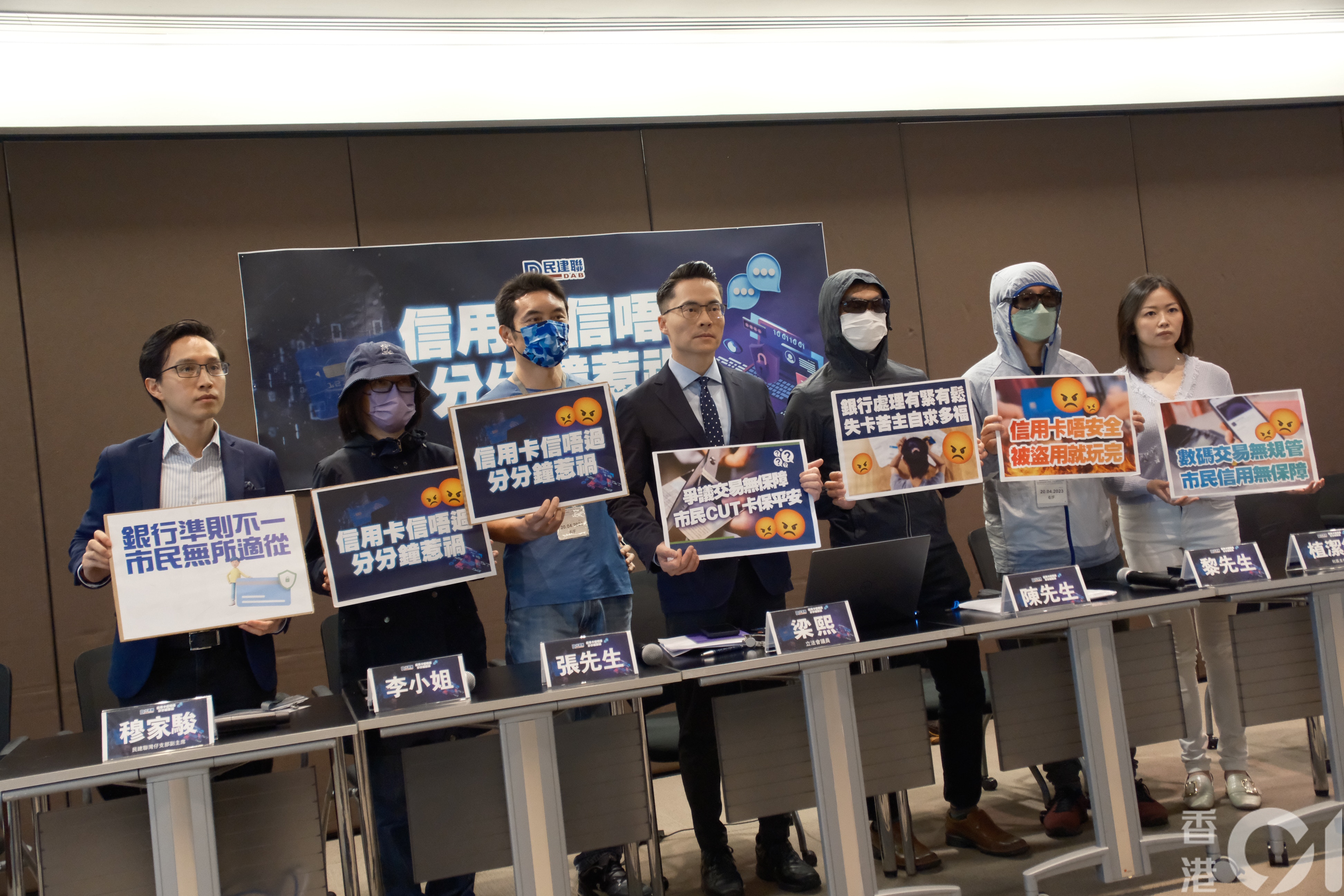 立法會議員梁熙（左四）與民建聯灣仔支部副主席穆家駿（左一）、議員助理植潔鈴（右一）幾位信用卡被盜的苦主見記者。（盧翊銘攝）