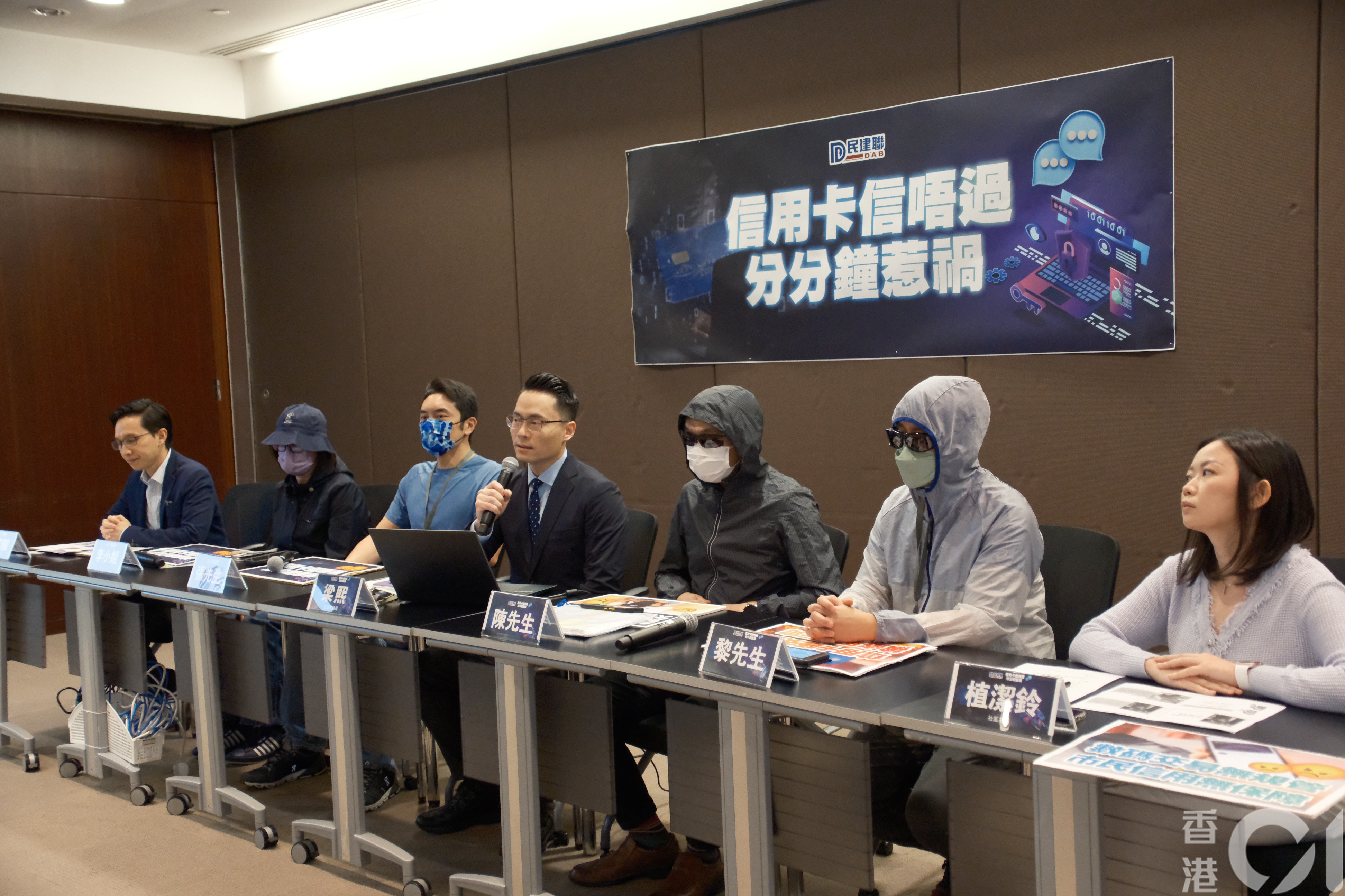 立法會議員梁熙（左四）與民建聯灣仔支部副主席穆家駿（左一）、議員助理植潔鈴（右一）幾位信用卡被盜的苦主見記者。（盧翊銘攝）