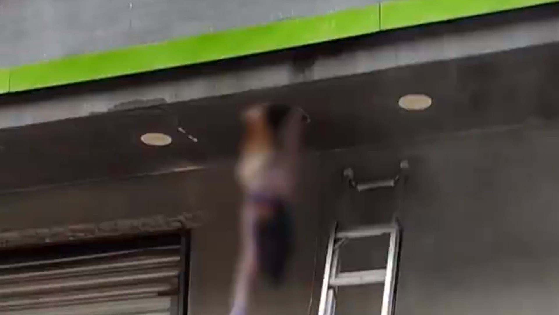 一名女子在曬衣服時不慎從10樓跌落至2樓,整個人倒掛懸吊在窗外。(微博@中國消防) 一名女子在曬衣服時不慎從10樓跌落至2樓,整個人倒掛懸吊在窗外。(微博@中國消防)