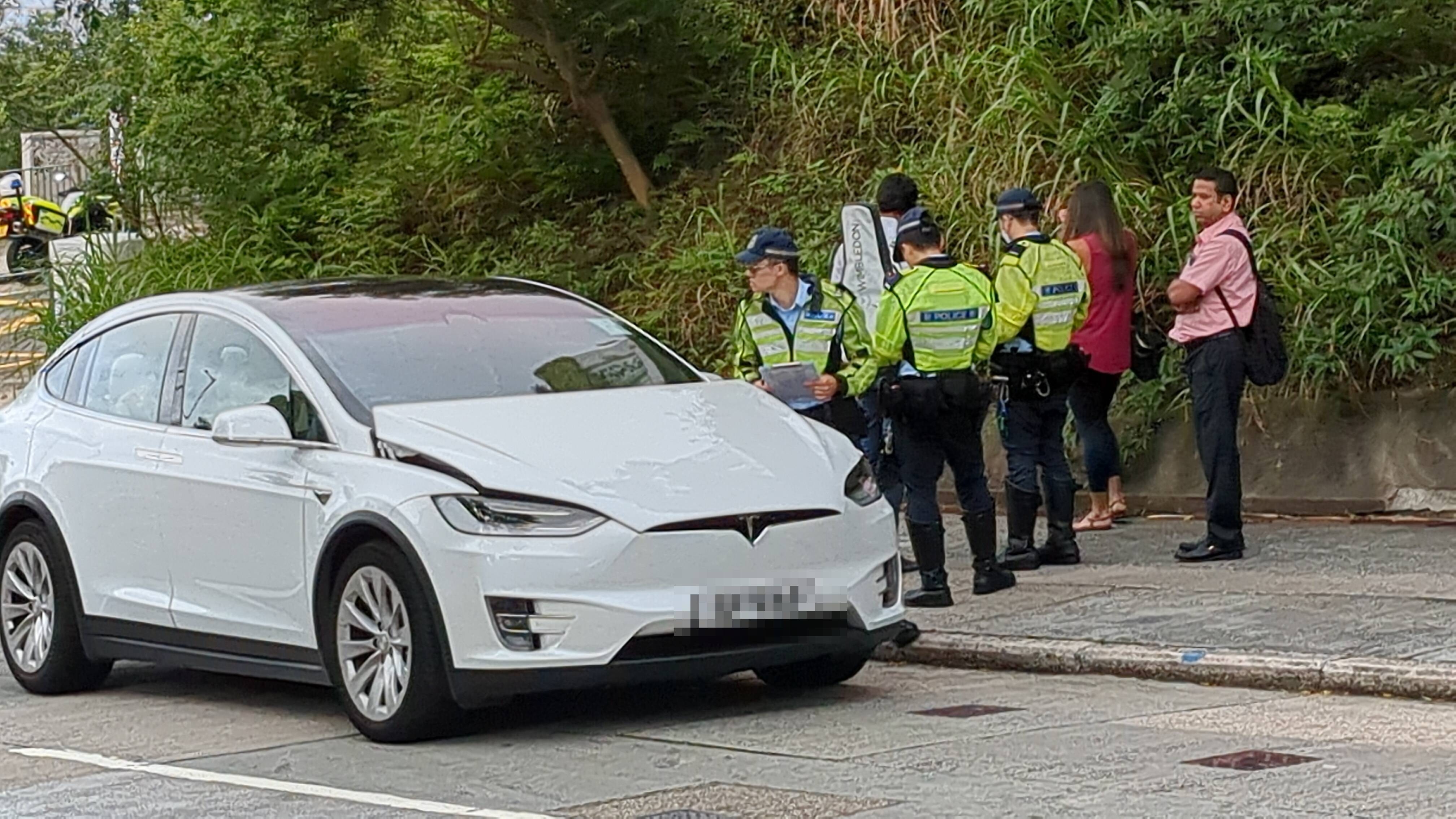 女司機及男乘客（白衫）在場助查，另一名男子（右）到場協助處理車務。（黃偉民攝）
