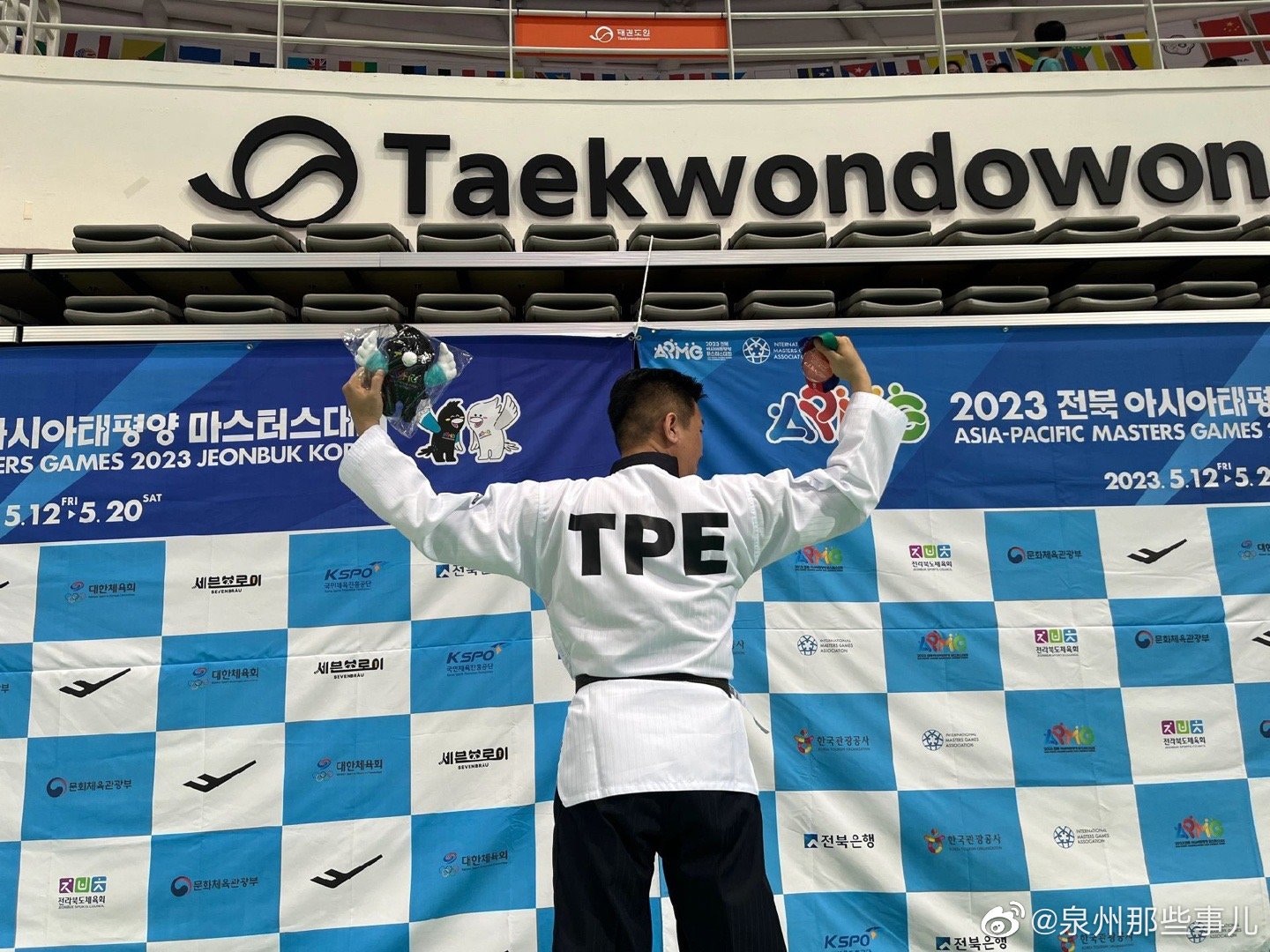 代表中華台北出戰的跆拳道選手李東憲，在頒獎時舉起五星紅旗。（微博）