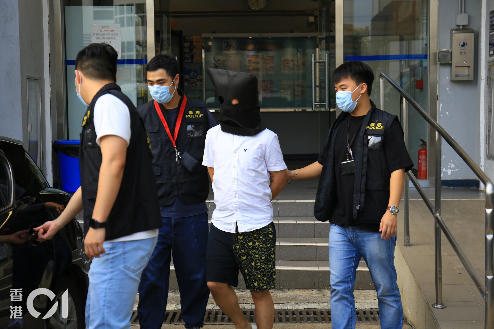 疑犯黑布蒙頭由警員押走。(黃廸雯攝) 疑犯黑布蒙頭由警員押走。(黃廸雯攝)