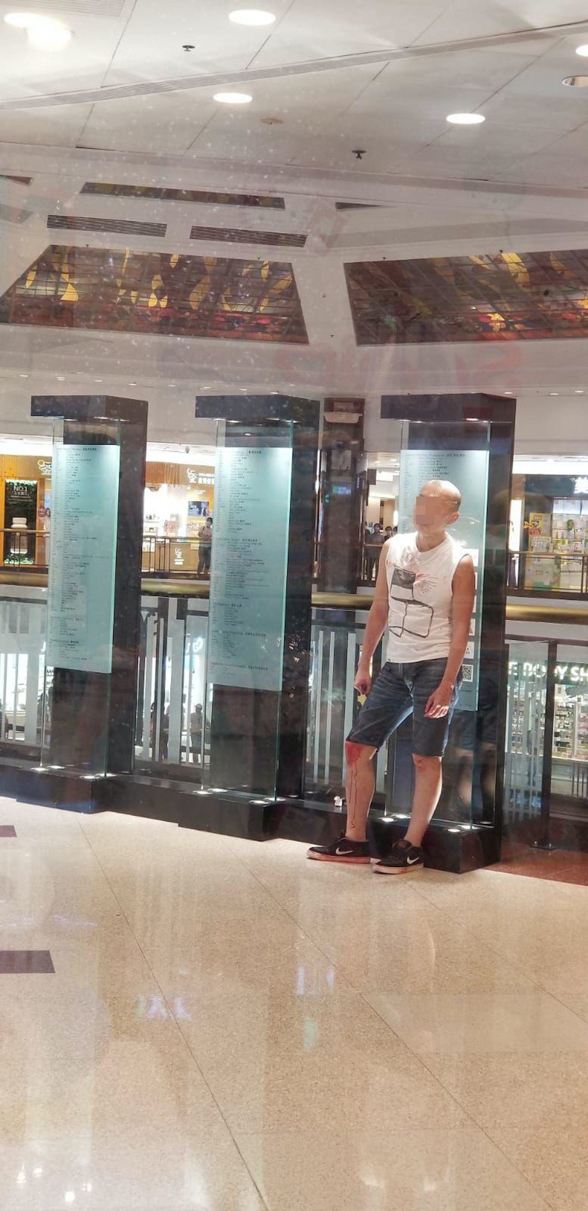 疑兇案發後滿身鮮血,呆站現場望着他人為傷者急救。(網上圖片)