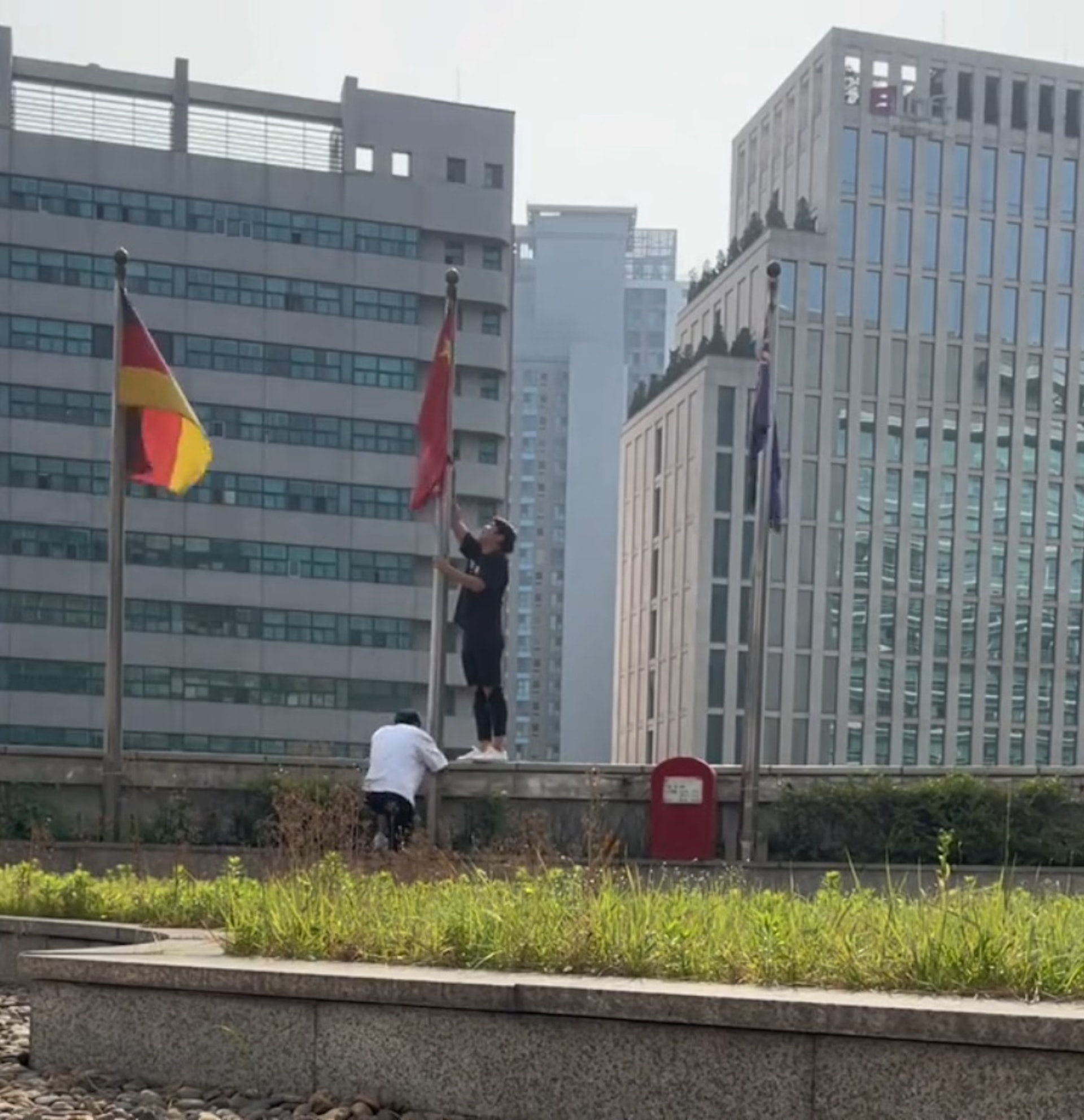 王先生和同事自行到平台位置,將捆綁中國國旗的繩子解開。(影片截圖) 王先生和同事自行到平台位置,將捆綁中國國旗的繩子解開。(影片截圖)
