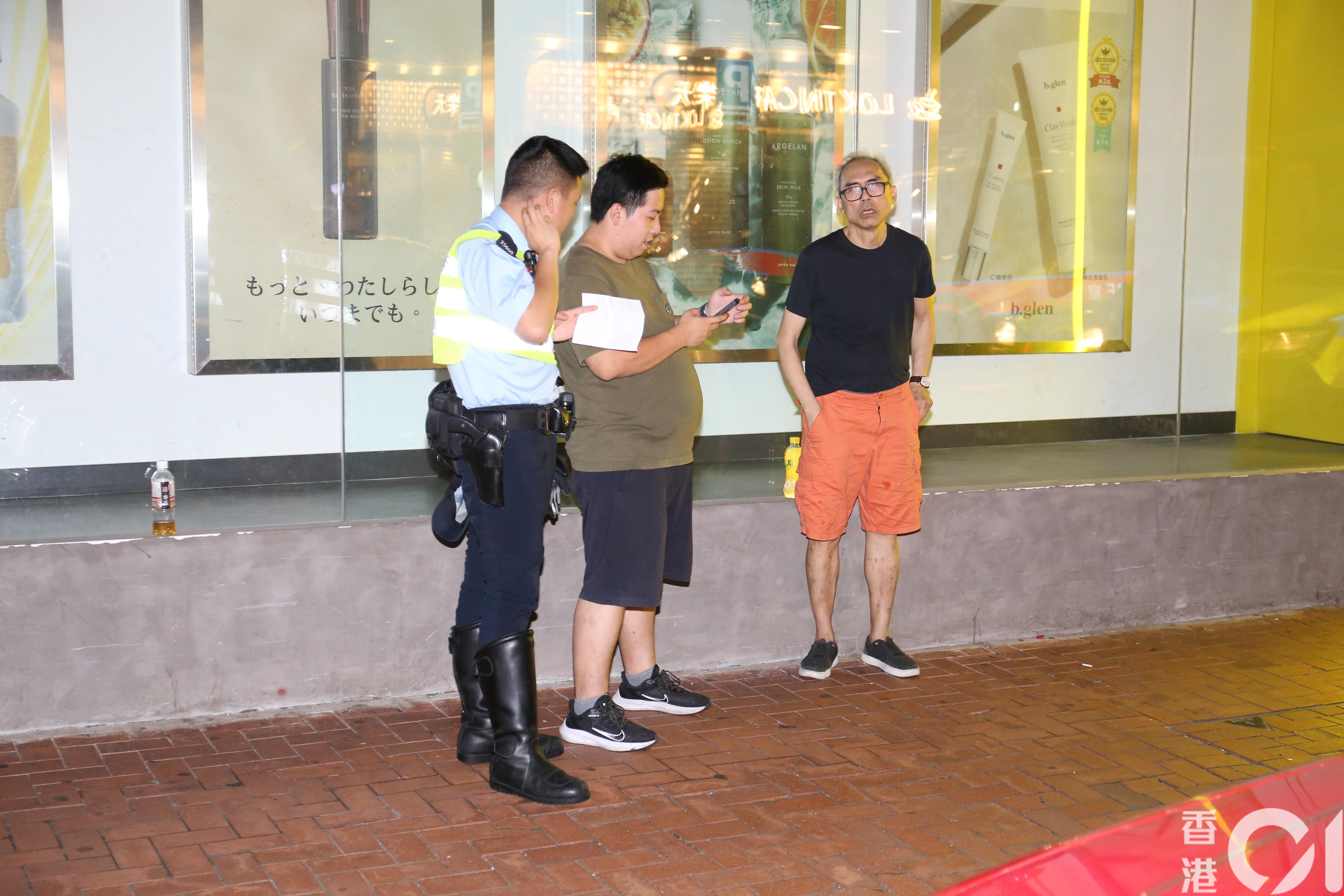 周姓的士司機（橙褲）在場協助警方調查。（黃江奇攝）