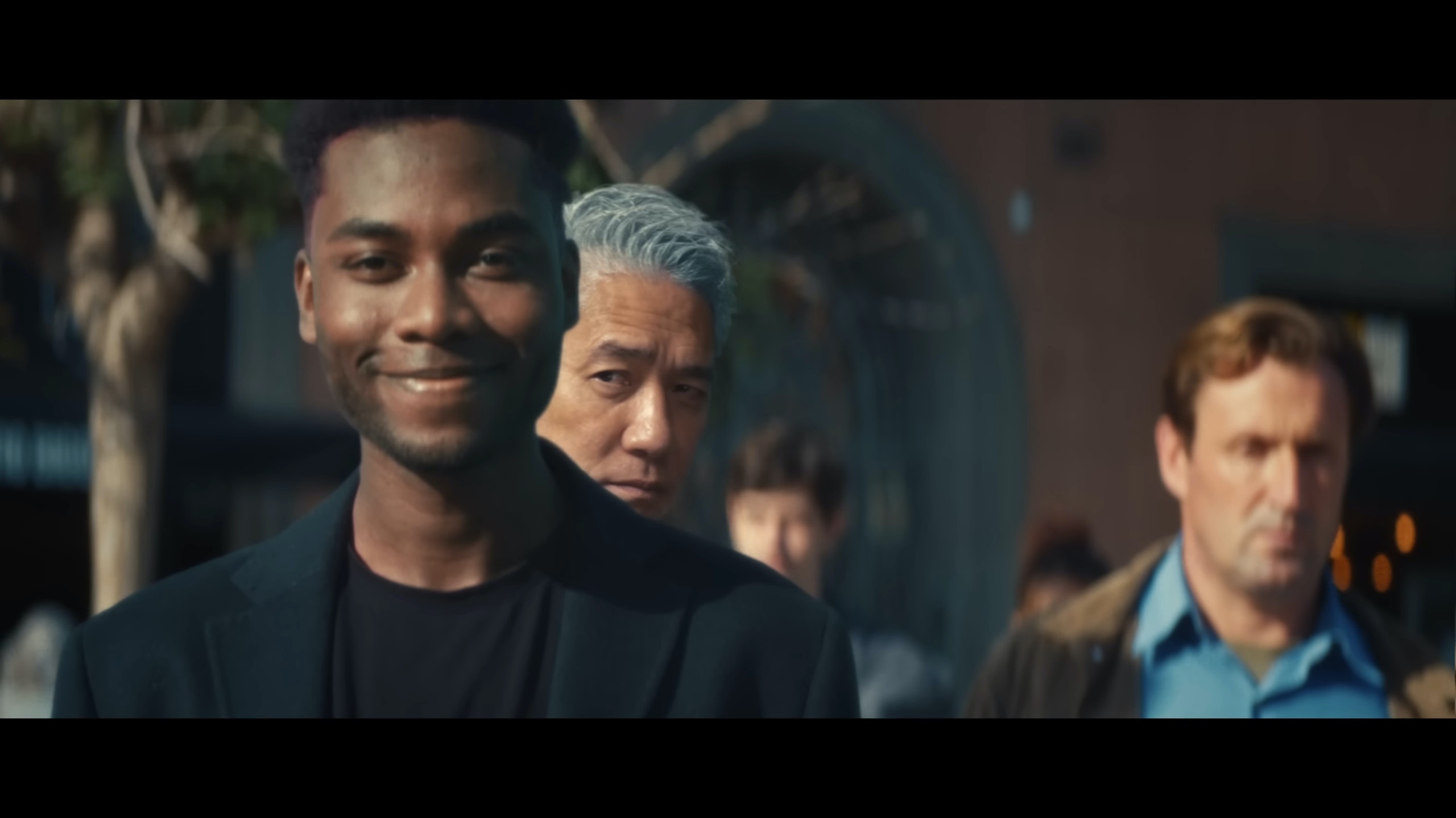 MV中約2分鐘時可以見到影帝梁朝偉驚現，他站在一位黑人背後。(MV截圖)