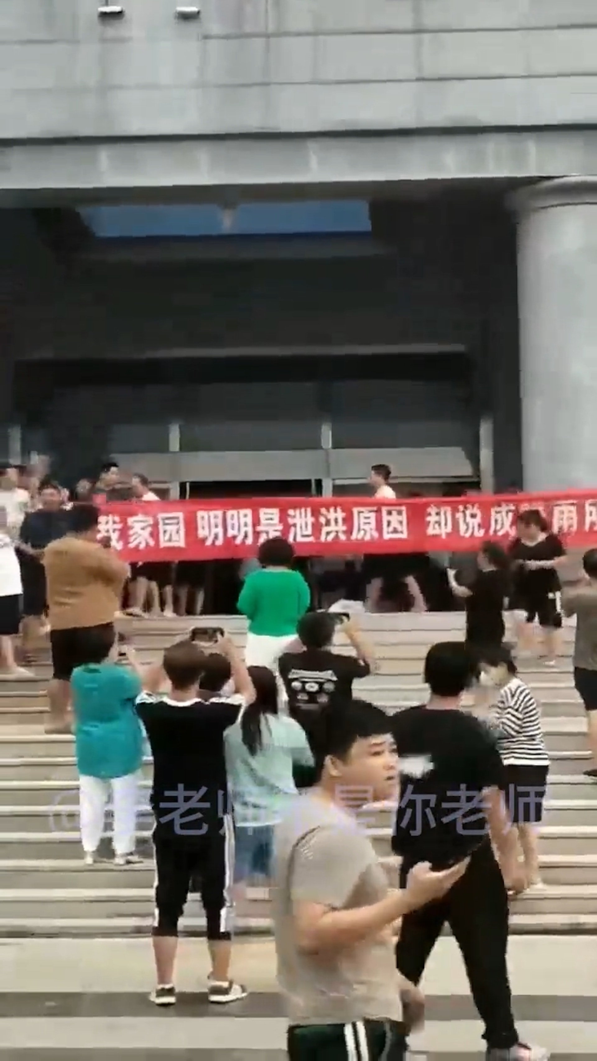 多名霸州市災民4日前往當地政府大樓進行抗議,在現場高舉紅色橫幅布條:「還我家園,明明是泄洪原因,卻說降雨所致」。(影片截圖) 多名霸州市災民4日前往當地政府大樓進行抗議,在現場高舉紅色橫幅布條:「還我家園,明明是泄洪原因,卻說降雨所致」。(影片截圖)