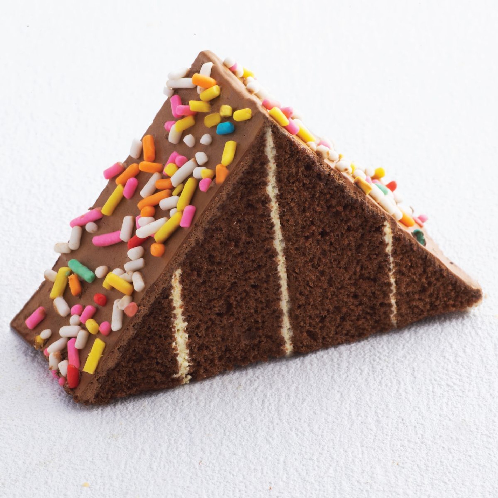 朱古力三角蛋糕，每層蛋糕隔著薄薄忌廉，表面鋪上彩虹碎粒，濃郁的朱古力風味與海綿蛋糕完美契合。（圖片來源：聖安娜餅屋官方網站）