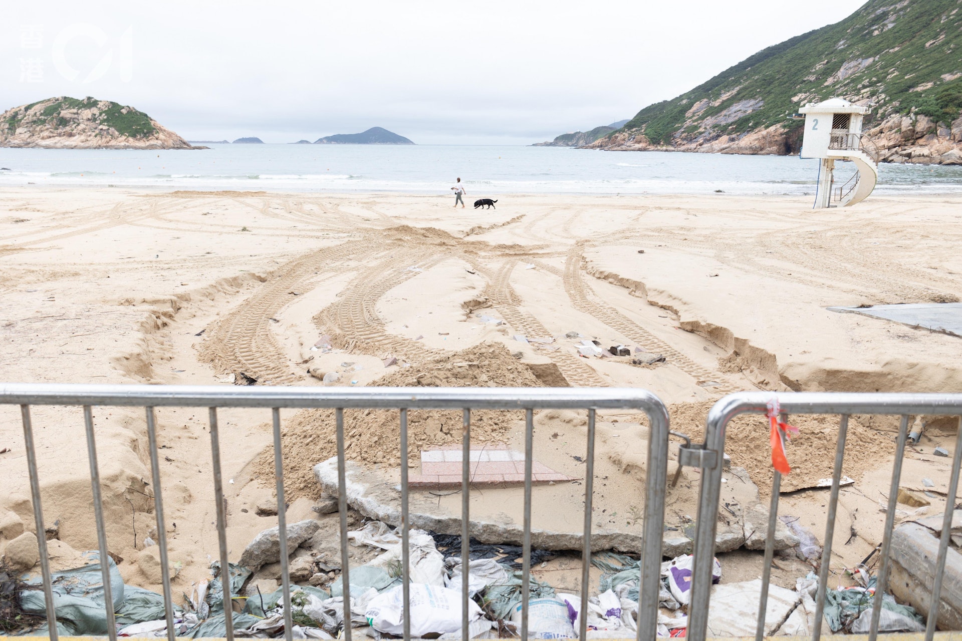 沙灘近岸邊有沙被沖走令水管外露,救生員堆沙,掩蓋外露部分。(梁鵬威攝) 沙灘近岸邊有沙被沖走令水管外露,救生員堆沙,掩蓋外露部分。(梁鵬威攝)