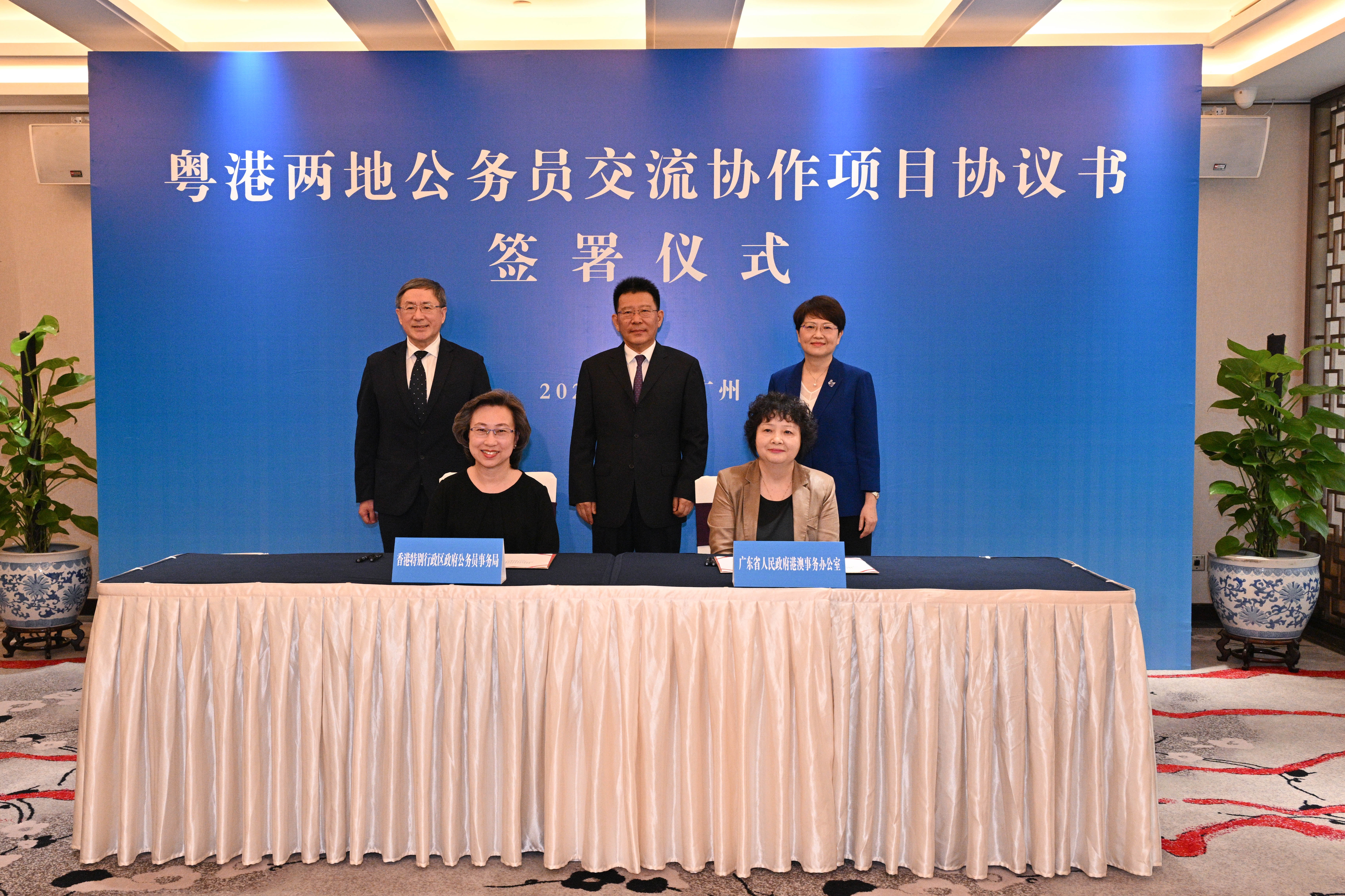 公務員事局局長楊何蓓茵（前左）與廣東省港澳辦主任李煥春（前右），在國務院港澳辦副主任王靈桂（後排中）、政務司副司長卓永興（後排左）、廣東省人民政府副省長馮玲（後排右）見證下，簽署《關於內地大灣區城市和香港特別行政區兩地公務員交流協作項目協議書》。（公務員事務局）