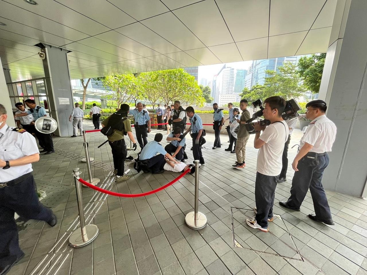 白衫男子用生果刀襲擊政總保安，被多名保安合力制服。（點新聞提供圖片）