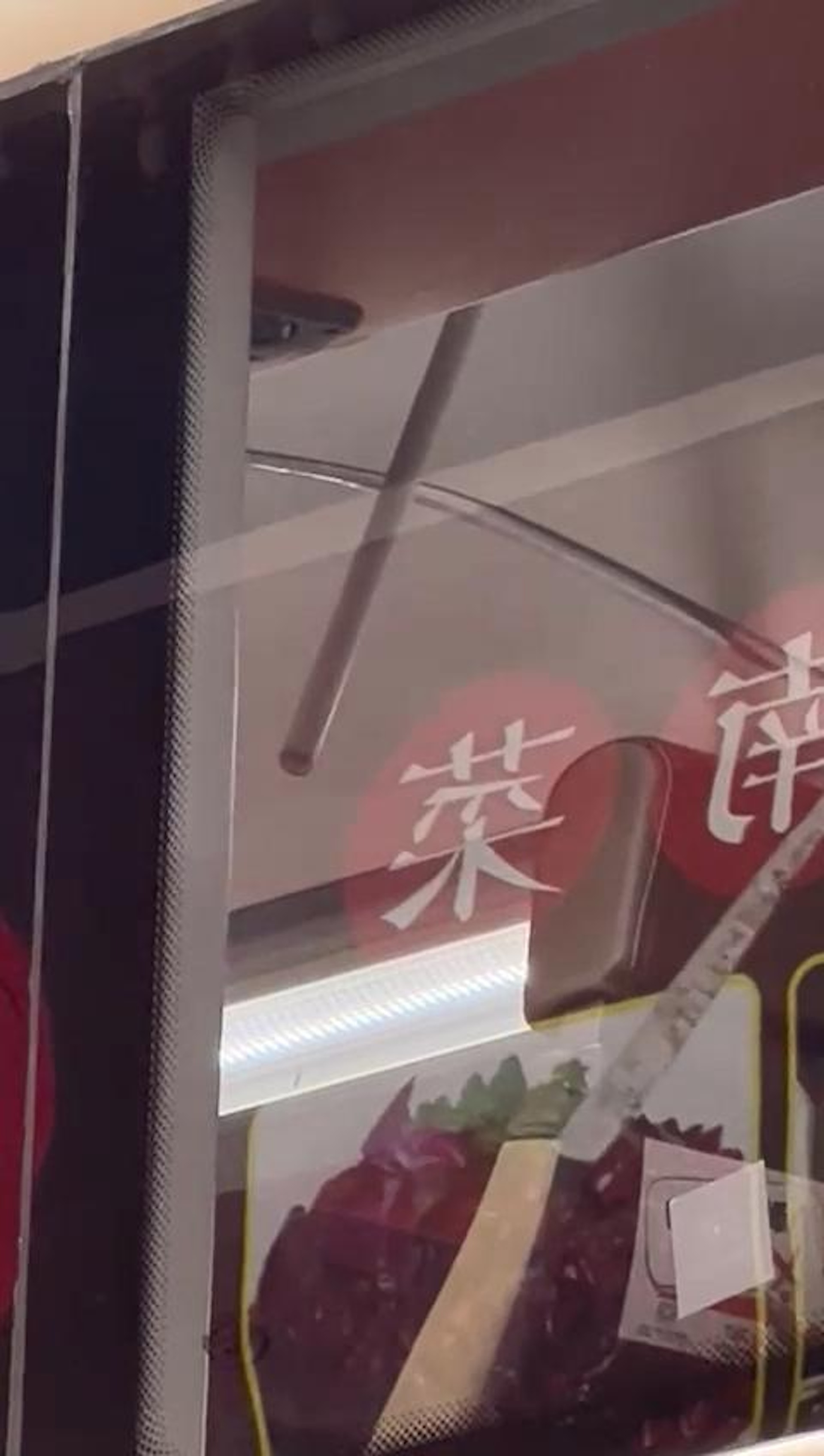 一輛九巴駛經油麻地彌敦道時,車頂遭從天而降的膠喉插穿。(讀者提供片段截圖) 一輛九巴駛經油麻地彌敦道時,車頂遭從天而降的膠喉插穿。(讀者提供片段截圖)