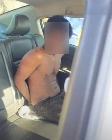 疑犯半裸坐上警車照片曝光後來民眾謾罵。（中國報）