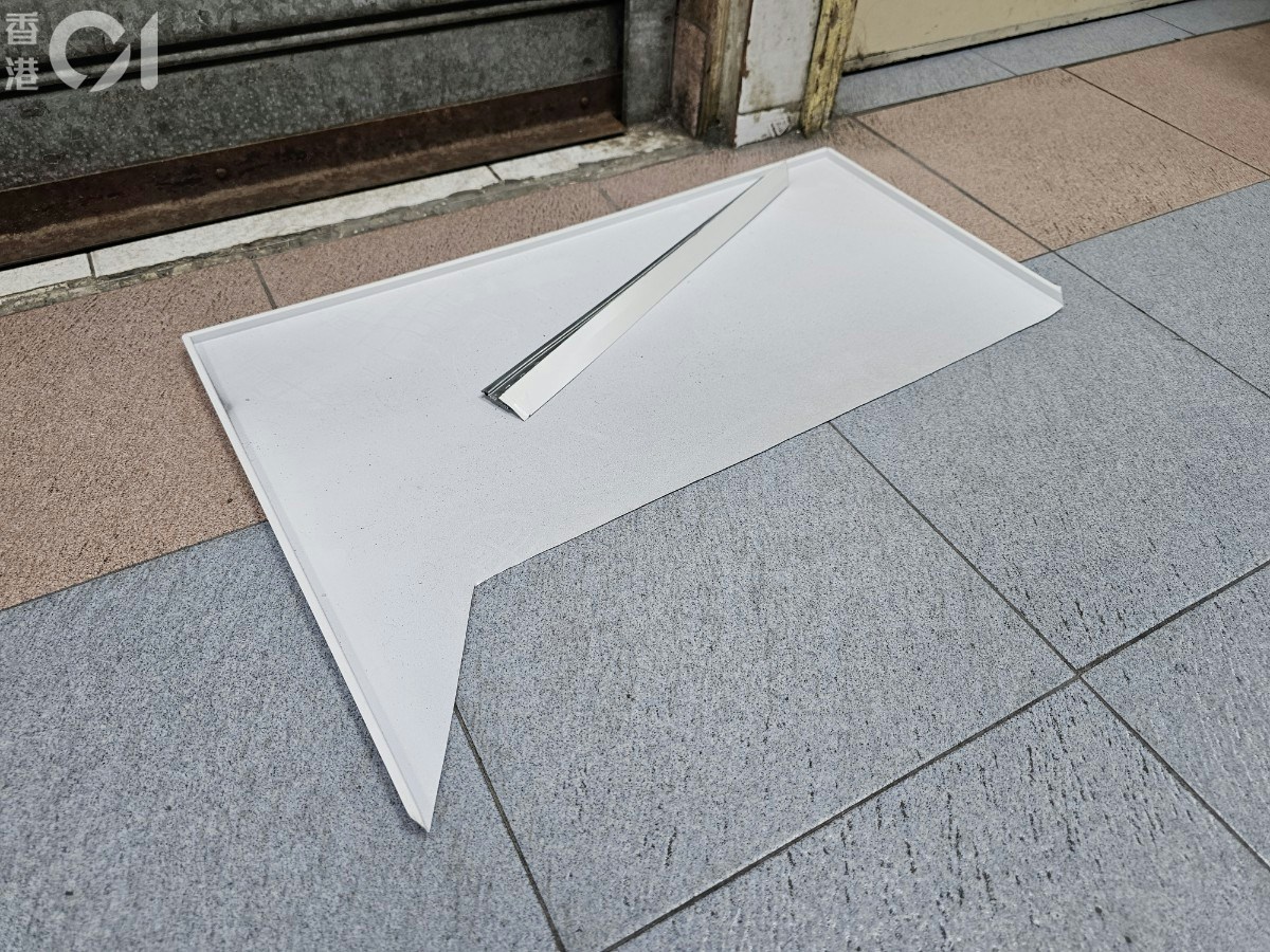 一塊約半呎乘一呎鋁鐵板塊，跌在一所電子零件店舖門外。（梁偉權攝）