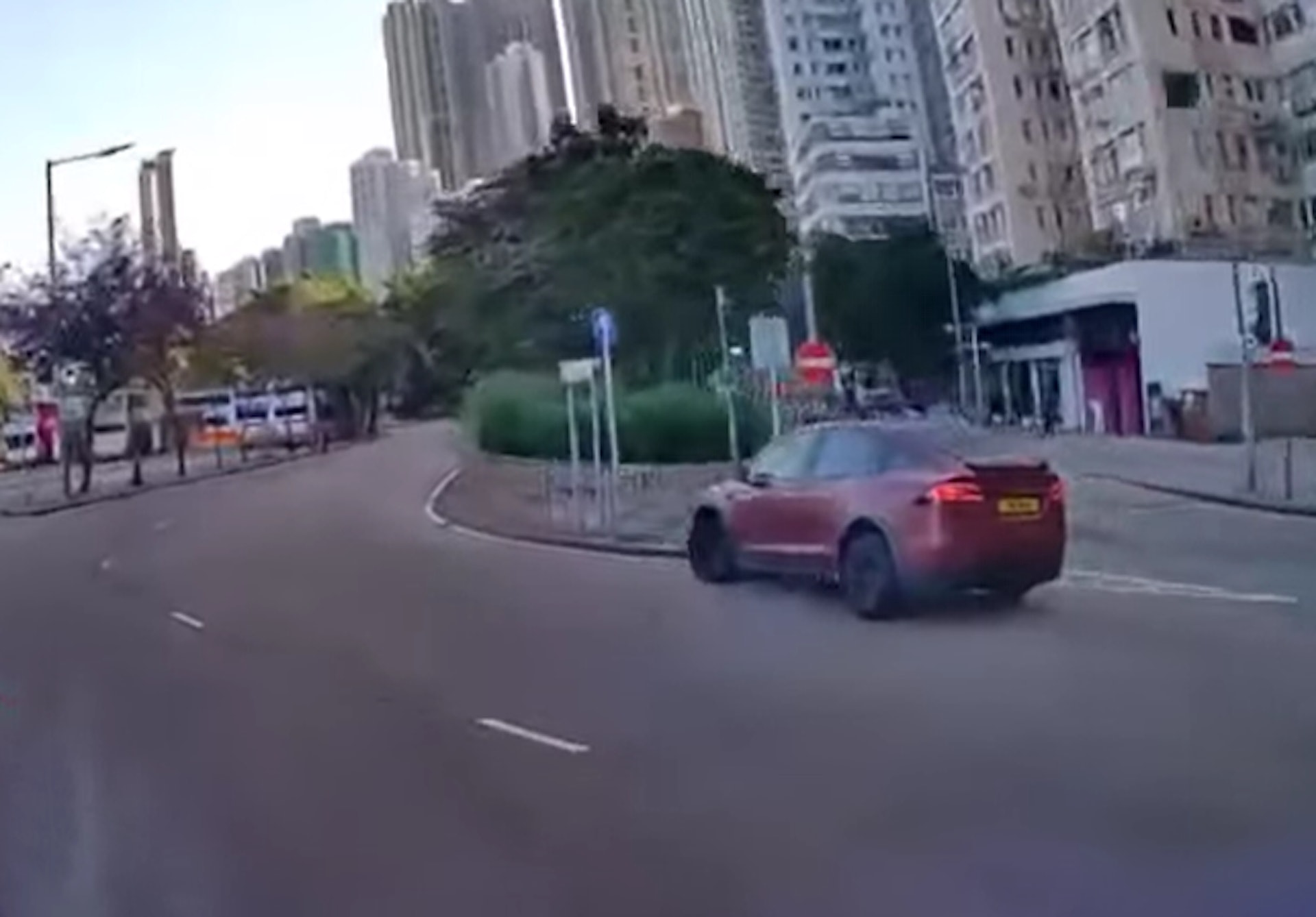 涉事紅色私家車今早(19日)9時許沿堅尼地城新海旁道行駛時,懷疑發現禁止直駛入前方路段而欲急速轉彎入城西道,結果撞欄導致意外。(Facebook「車cam L(香港群組)」影片截圖)