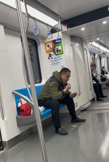上海地鐵一名男子在車廂內吃魚，更旁若無人地將魚骨吐在地面。（影片截圖）