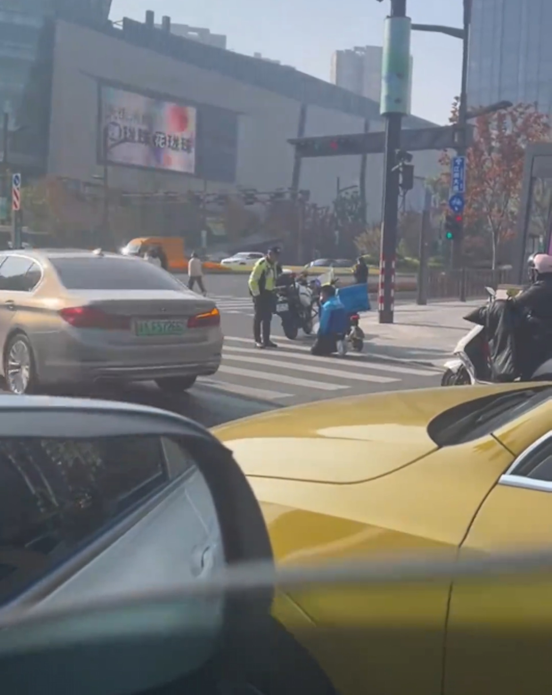 浙江杭州一名外賣員因闖紅燈被交通警攔截,期間一度下跪求情,惟遭拒後情緒崩潰,更大叫「我不活了」。(影片截圖) 浙江杭州一名外賣員因闖紅燈被交通警攔截,期間一度下跪求情,惟遭拒後情緒崩潰,更大叫「我不活了」。(影片截圖)