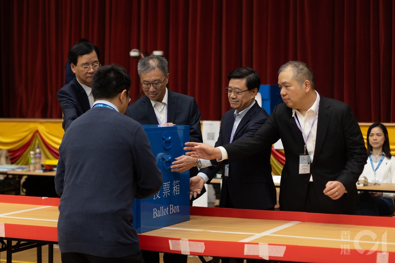 區議會選舉12月10日午夜結束,設於皇仁書院的投票站在12月11日凌晨1時許開始點票,特首李家超(右二)及選管會委員石丹理(左一)、主席陸啟康法官(左二)和文本立(右一)到場進行倒出票箱儀式。(梁鵬威攝) 區議會選舉12月10日午夜結束,設於皇仁書院的投票站在12月11日凌晨1時許開始點票,特首李家超(右二)及選管會委員石丹理(左一)、主席陸啟康法官(左二)和文本立(右一)到場進行倒出票箱儀式。(梁鵬威攝)