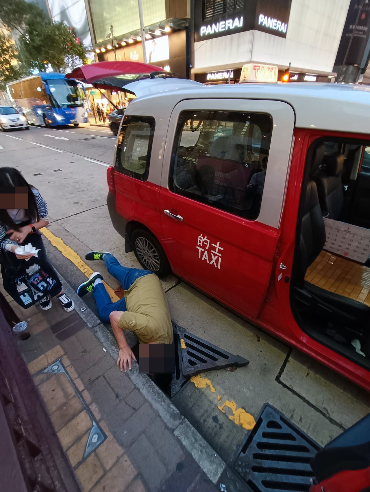 乘客不慎將手機跌落坑渠,的士司機「瞓身」趴地助拾回。(FB「車cam L(香港群組)」圖片) 乘客不慎將手機跌落坑渠,的士司機「瞓身」趴地助拾回。(FB「車cam L(香港群組)」圖片)