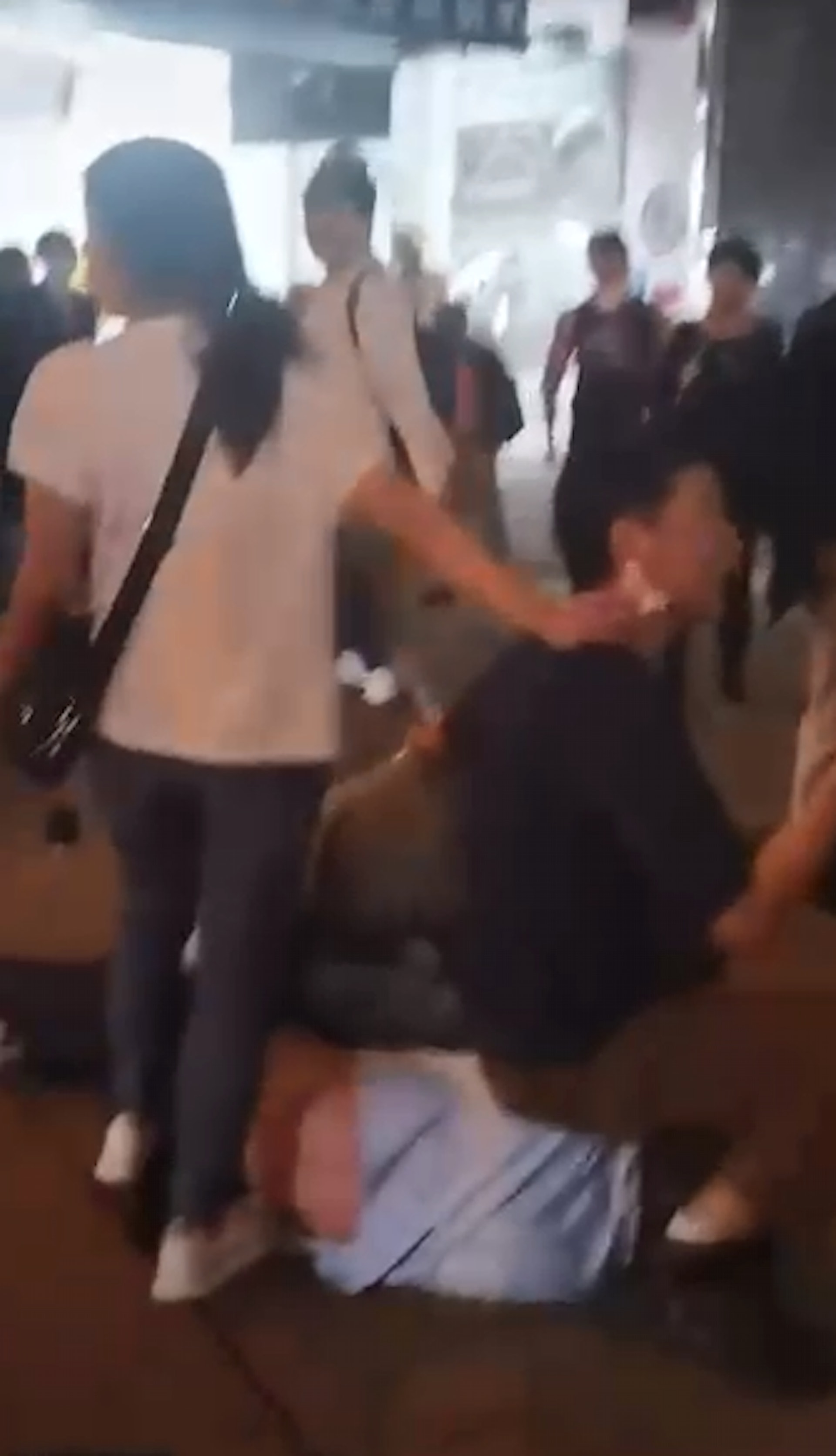 佐敦日前發生襲擊事件,兩男坐着一名身穿淺藍色上衣的男子,一名女子持染血紙巾站在旁邊。(網上片段截圖)