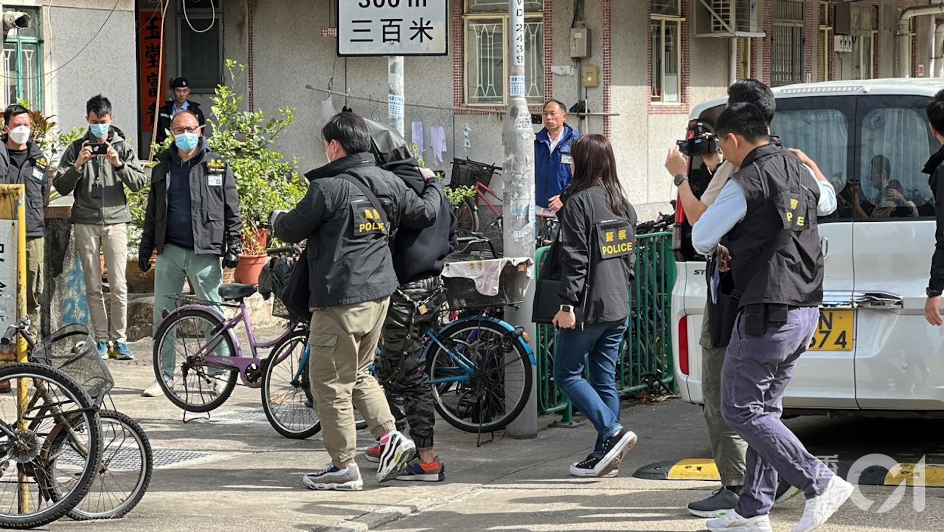 探員將蒙黑色頭套的疑兇帶落車,將他押返村屋重組案情。(馬耀文攝) 探員將蒙黑色頭套的疑兇帶落車,將他押返村屋重組案情。(馬耀文攝)