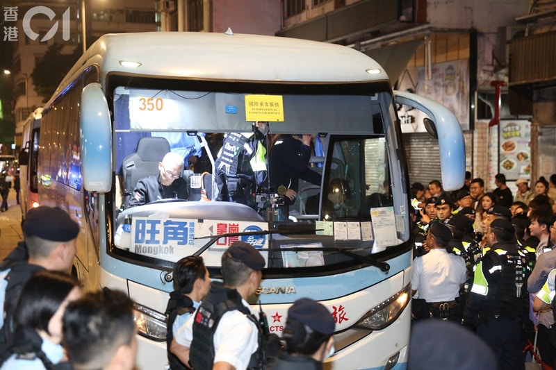 1月1日元旦凌晨，大批观看完除夕烟花倒数的内地旅客，在太子「跨境全日通」过境巴士站排队，部份人坐在路边等候，久久未能上车。(陈永武摄)