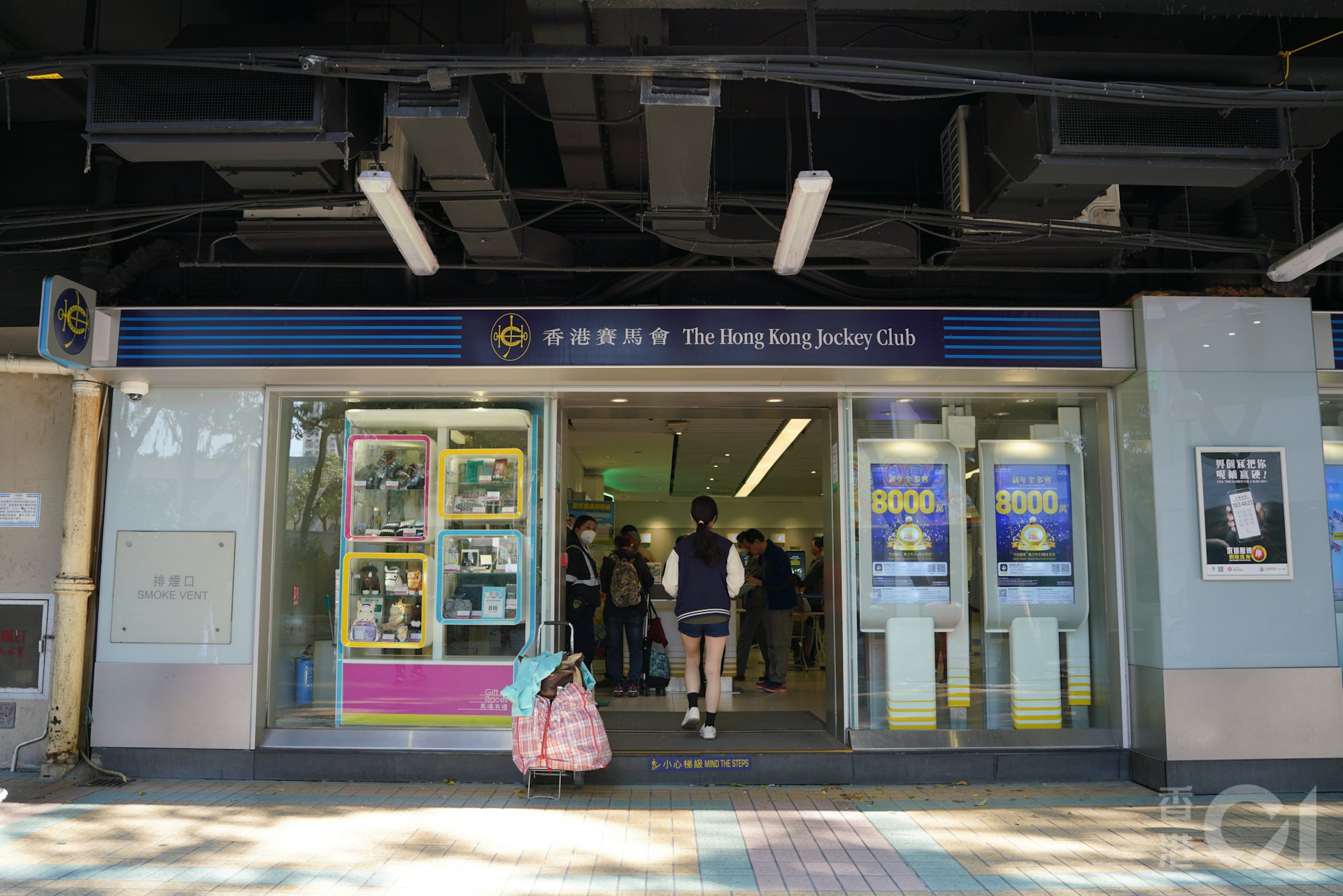 六合彩新年金多寶1月3日晚上攪珠,馬會估算頭奬一注獨中可獲8,000萬元。下午大埔廣場投注站有不少人到來買彩票。(黃浩謙攝) 六合彩新年金多寶1月3日晚上攪珠,馬會估算頭奬一注獨中可獲8,000萬元。下午大埔廣場投注站有不少人到來買彩票。(黃浩謙攝)
