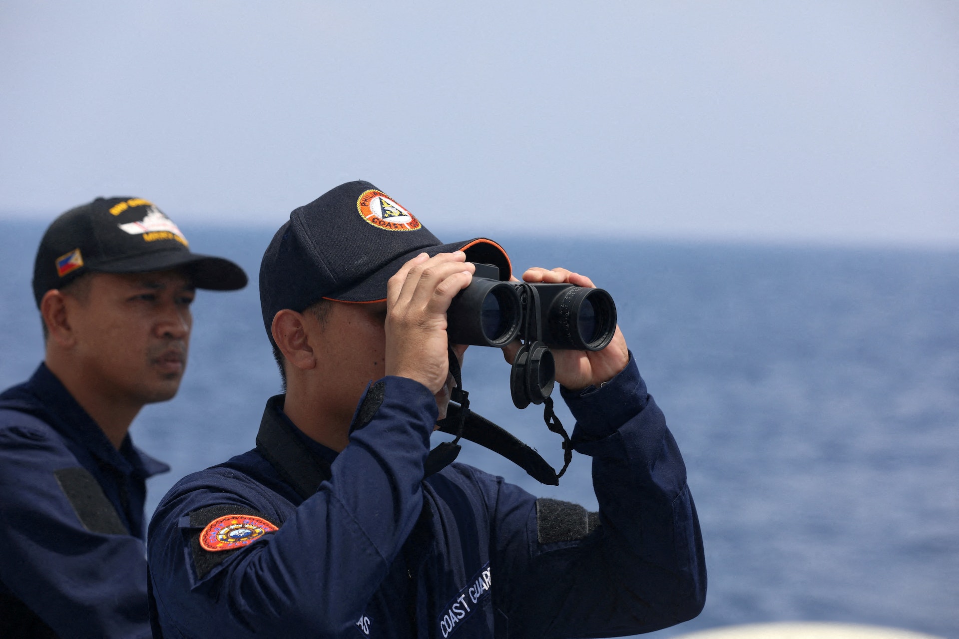圖為2023年10月4日,菲律賓海岸警衛隊人員以望遠鏡觀望南海。(Reuters) 圖為2023年10月4日,菲律賓海岸警衛隊人員以望遠鏡觀望南海。(Reuters)