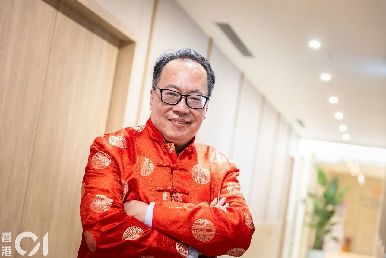 赤い中華風の上着を着て微笑む沈振盈さん