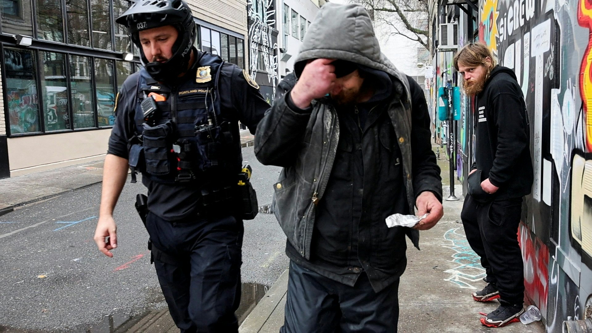 圖為2024年2月7日，美國俄勒岡州（Oregon）波特蘭（Portland）一名在街上吸食芬太尼的男子遭警員發出傳票。（Reuters）
