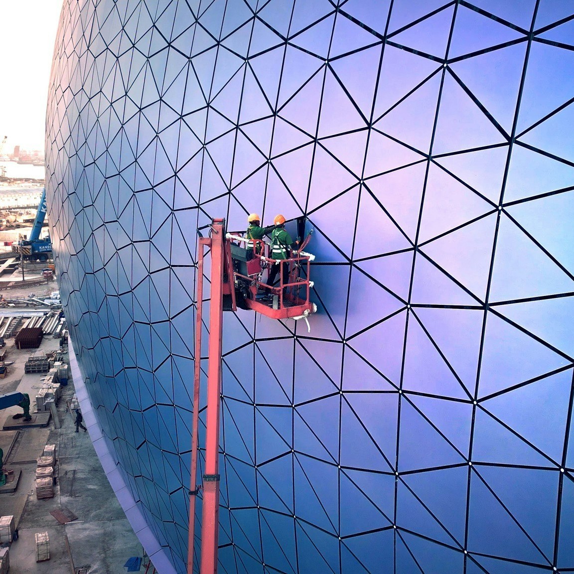 主场馆的表面由约27,000块不同形状的三角形铝质面板组成，外墙颜色能随著光线切入的角度变化而转变，呈现出幻彩蓝、耀目紫和闪烁银等多种色彩。（Facebook「飞越启德」群组图片）