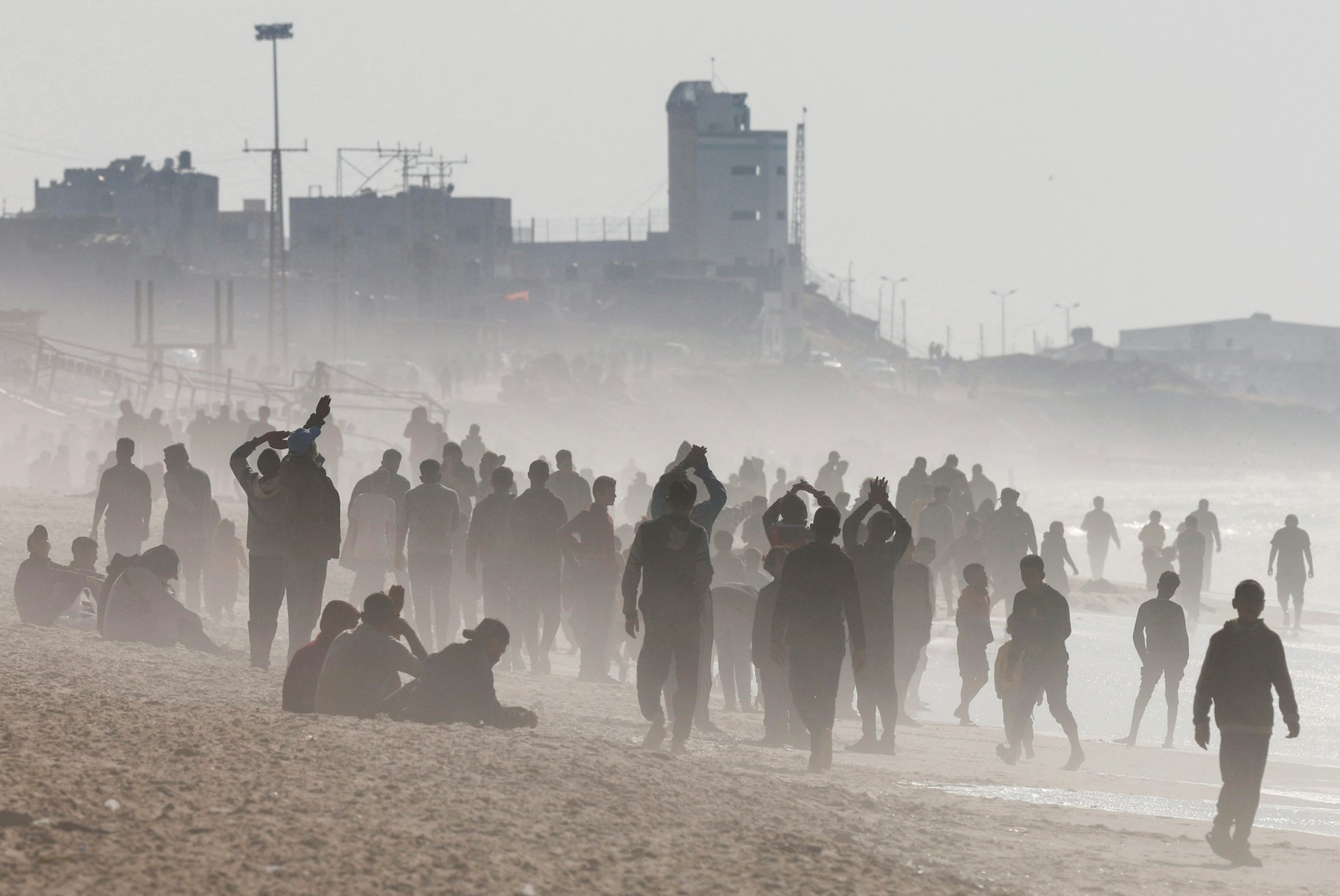 加沙南部一處海灘2024年2月27日有大批民眾聚集，等待人道物資包裹空投到該處（Reuters）