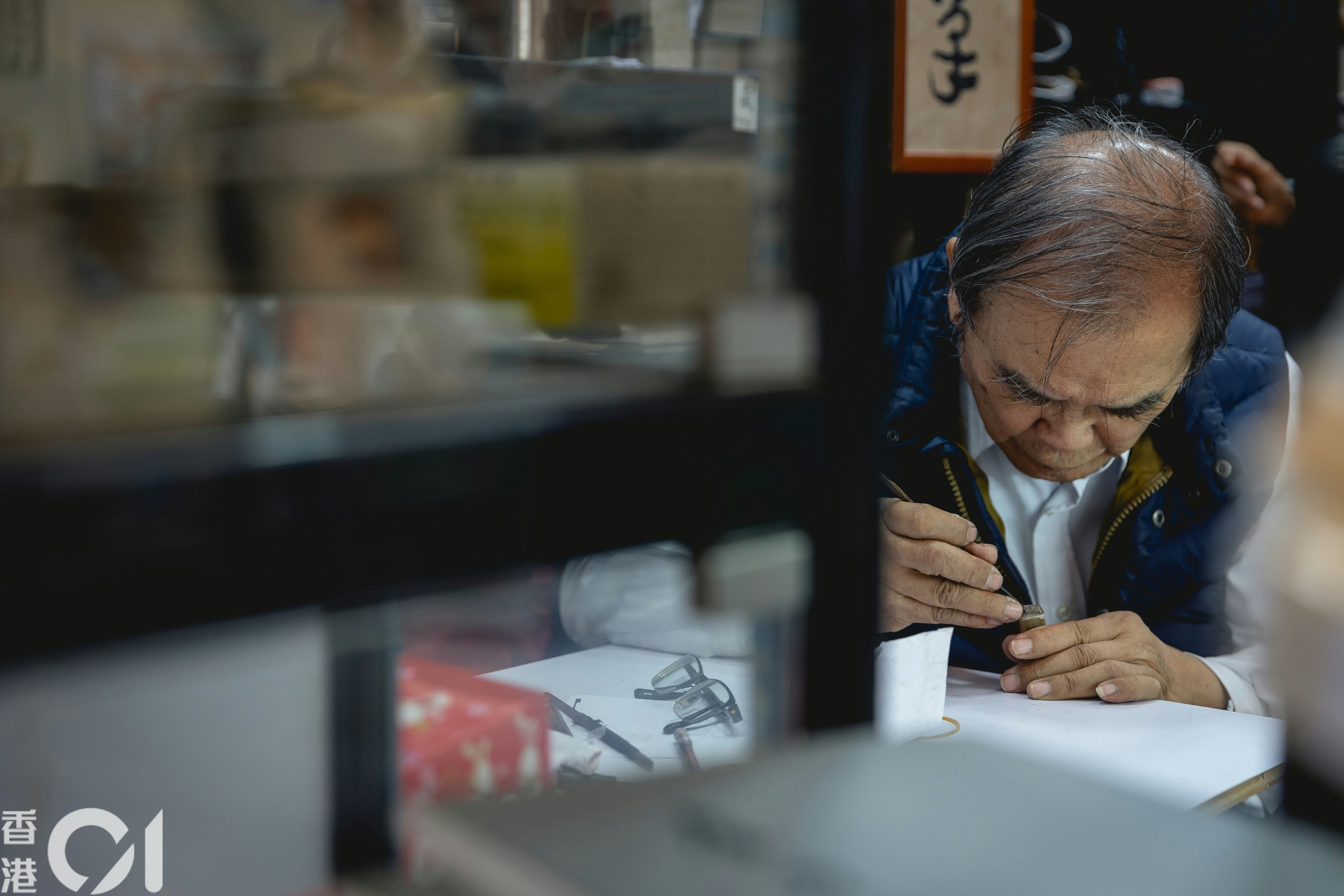 盧榮基正趕工雕製圖章。（夏家朗攝）