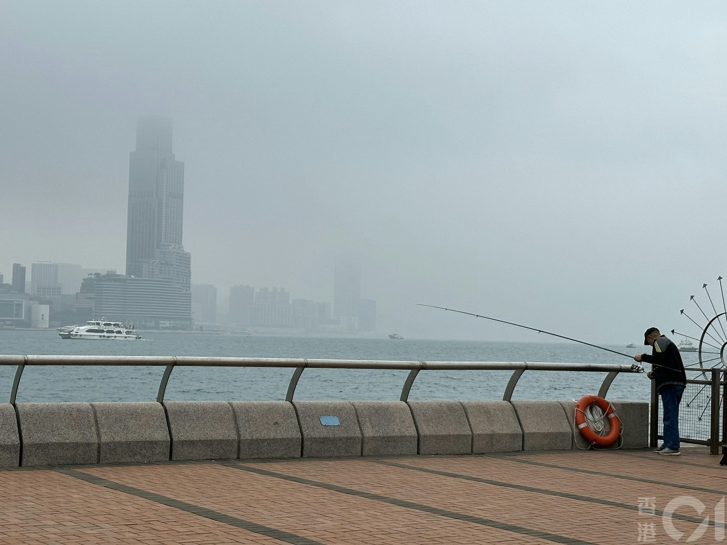 3月16日潮湿有雾，维港一片灰蒙蒙，在中环海滨望向对岸，可见部份大厦高层被云雾遮蔽。（倪清江摄）