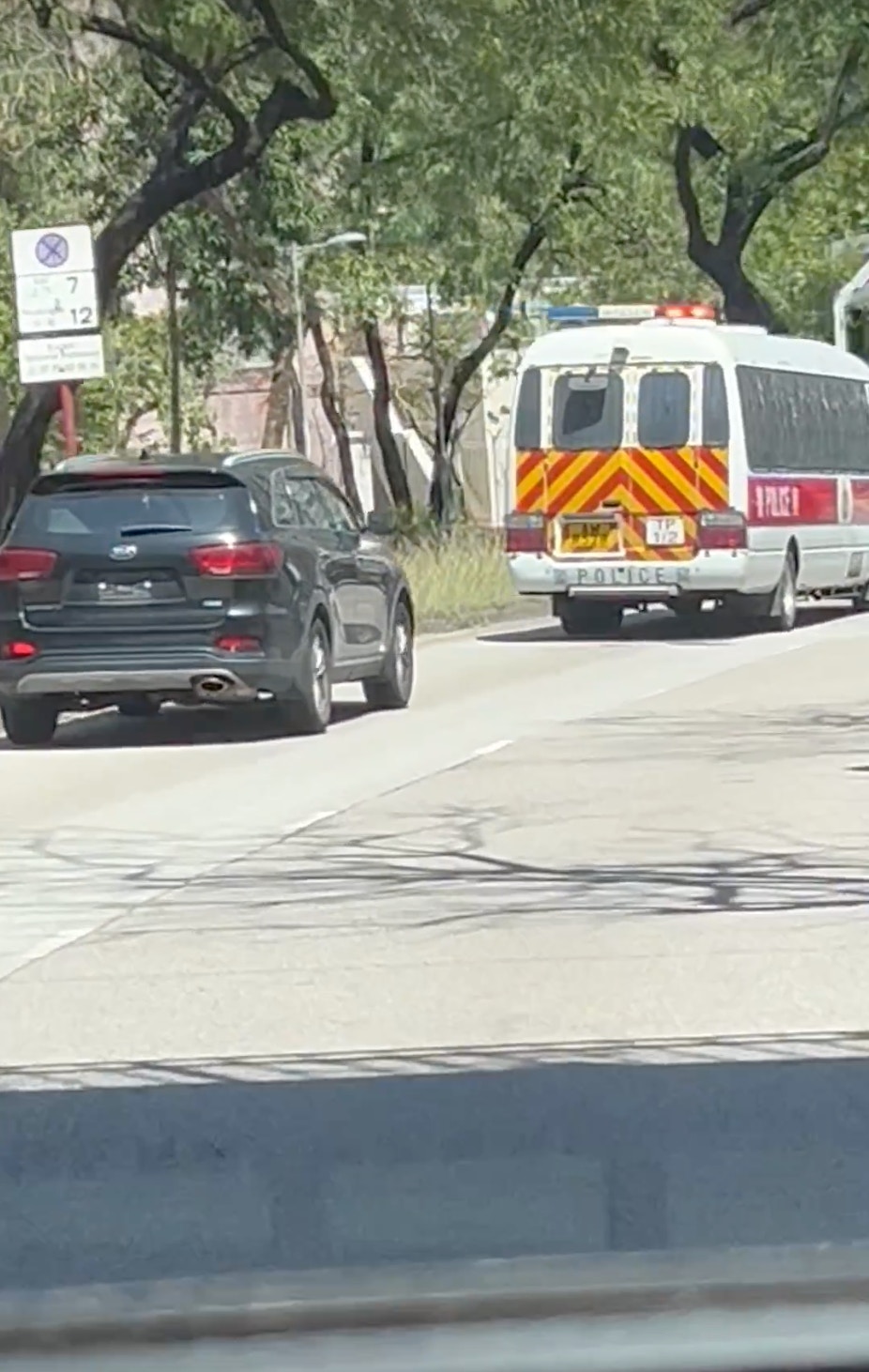 網上近日流傳一段短片，有人拍到一輛黑色七人車於馬路上行駛時，車尾未有掛上車牌，已觸犯法例，司機更一直跟着前方一輛警車行駛。（fb群組「車cam L（香港群組）」影片截圖）