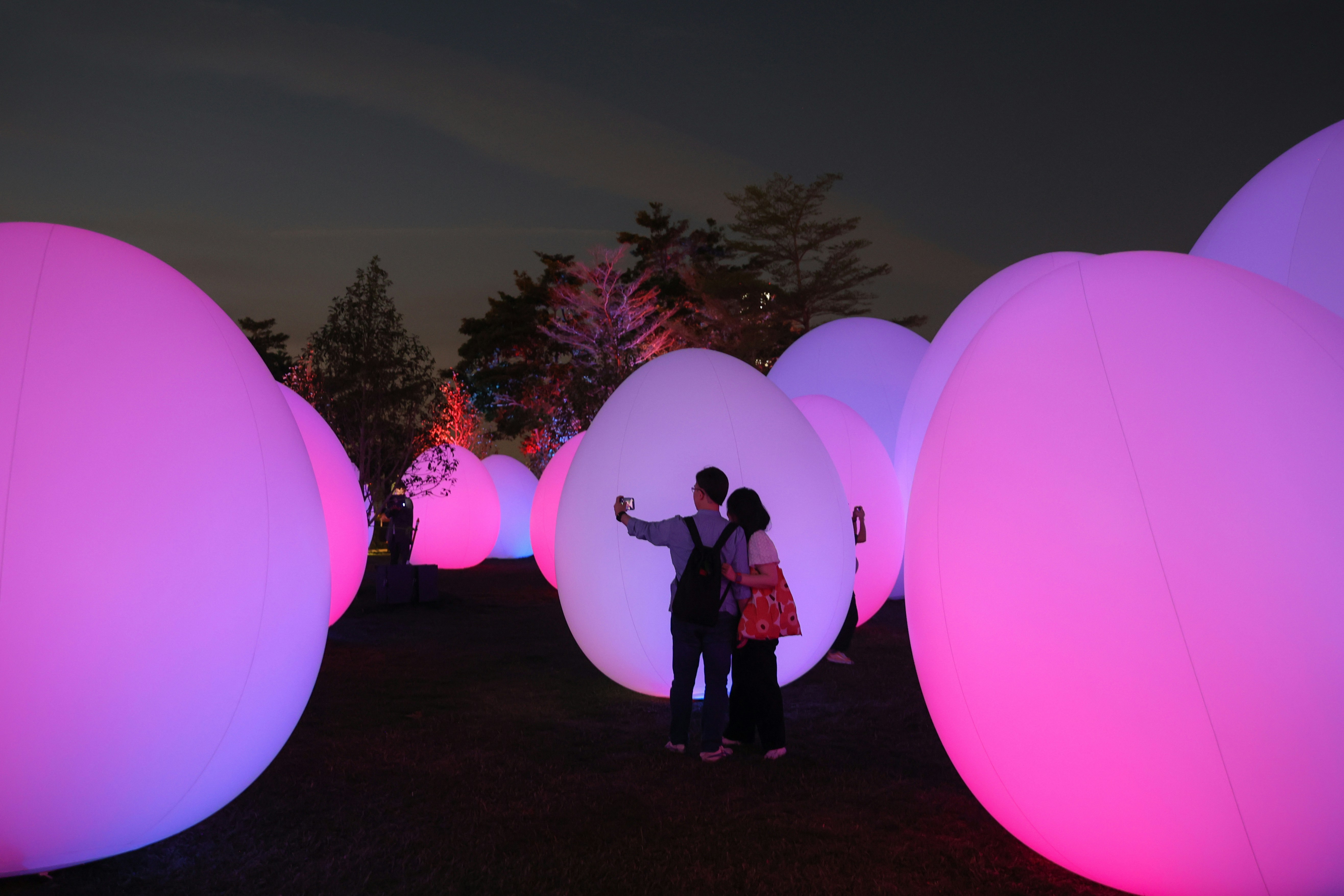 設於金鐘添馬公園的「teamLab：光漣」3月24日晚亮燈，有市民成功入內先行試行，不少人擺甫士打卡。（蘇煒然攝）